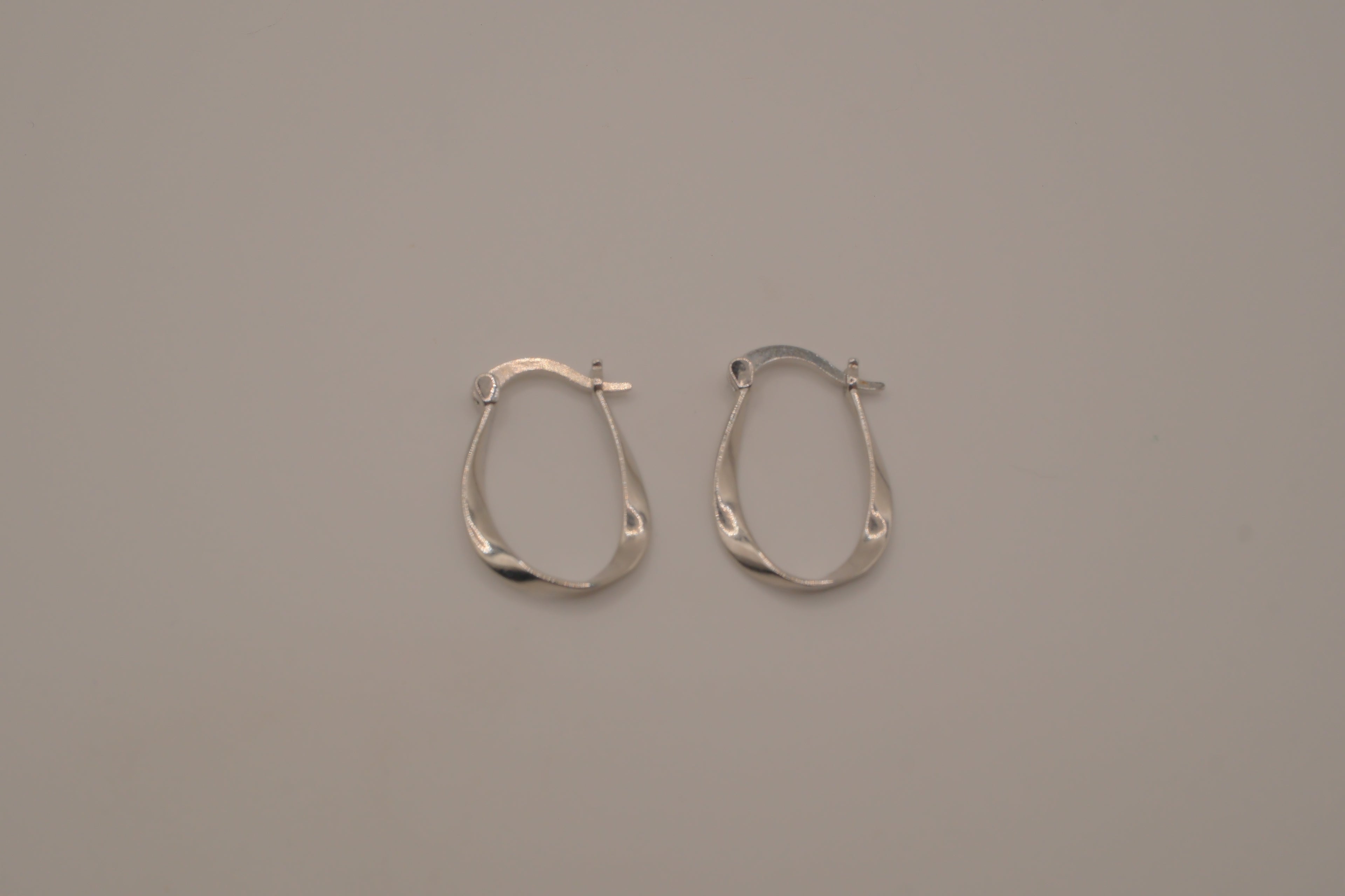 Sculptural, fluid-twisted sterling silver hoop earrings