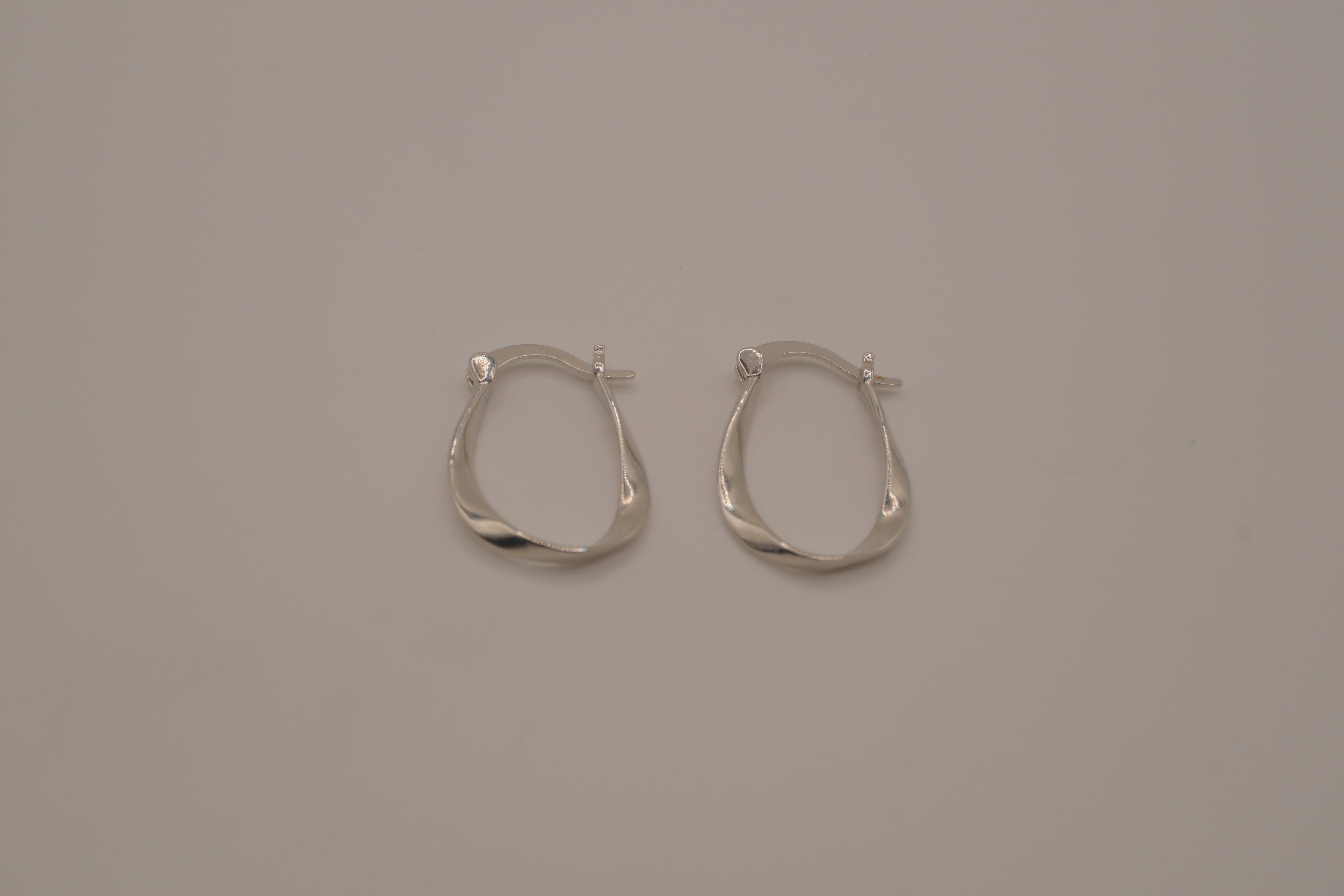 Sculptural, fluid-twisted sterling silver hoop earrings