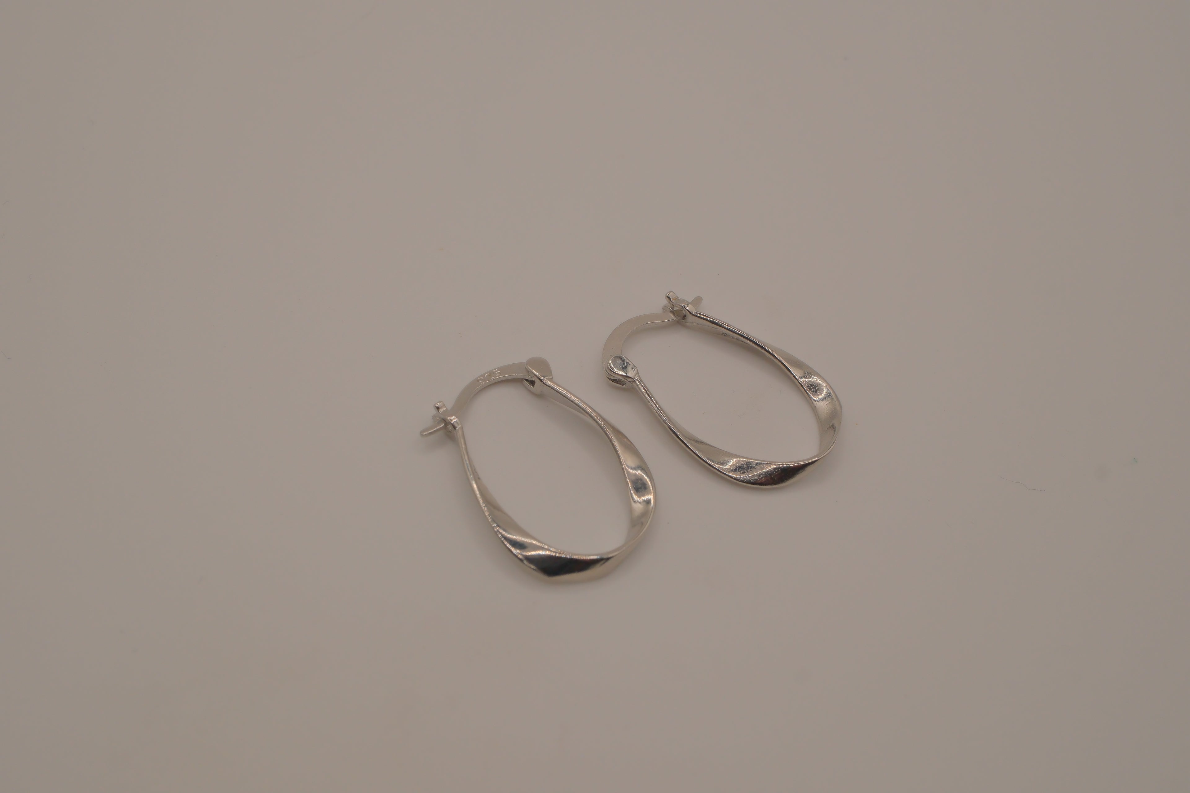 Sculptural, fluid-twisted sterling silver hoop earrings
