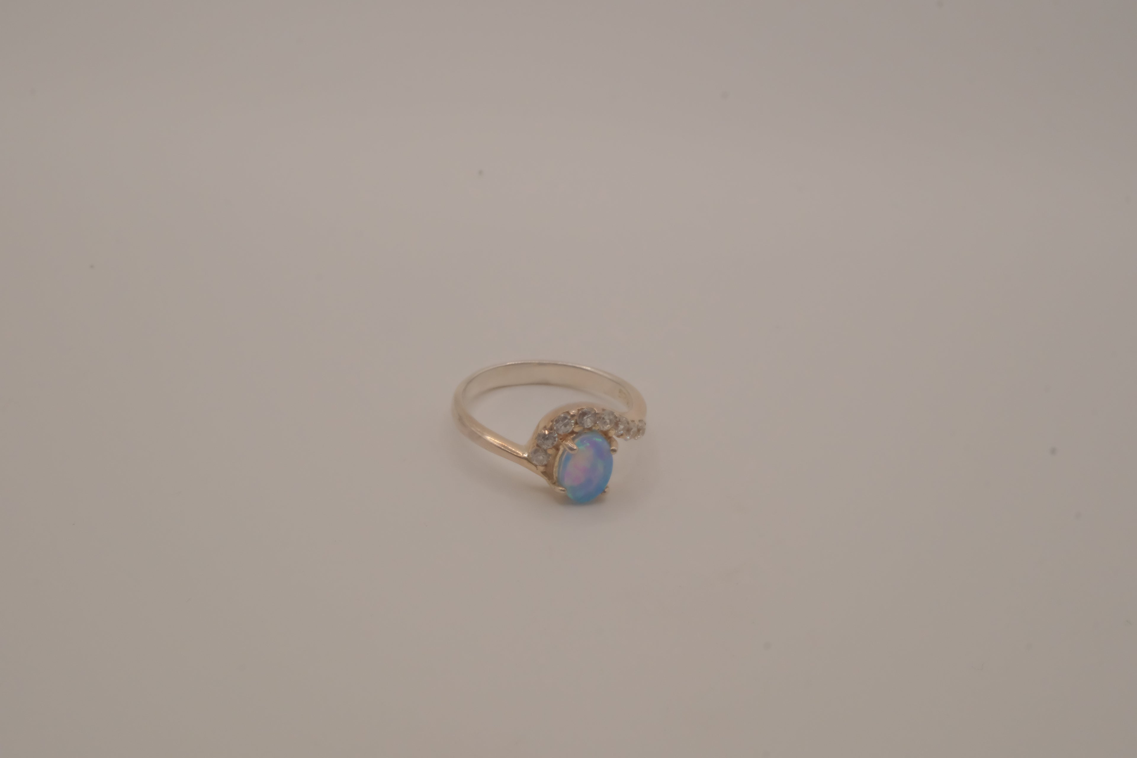 Sterling silver oval opal ring with a curved accent band