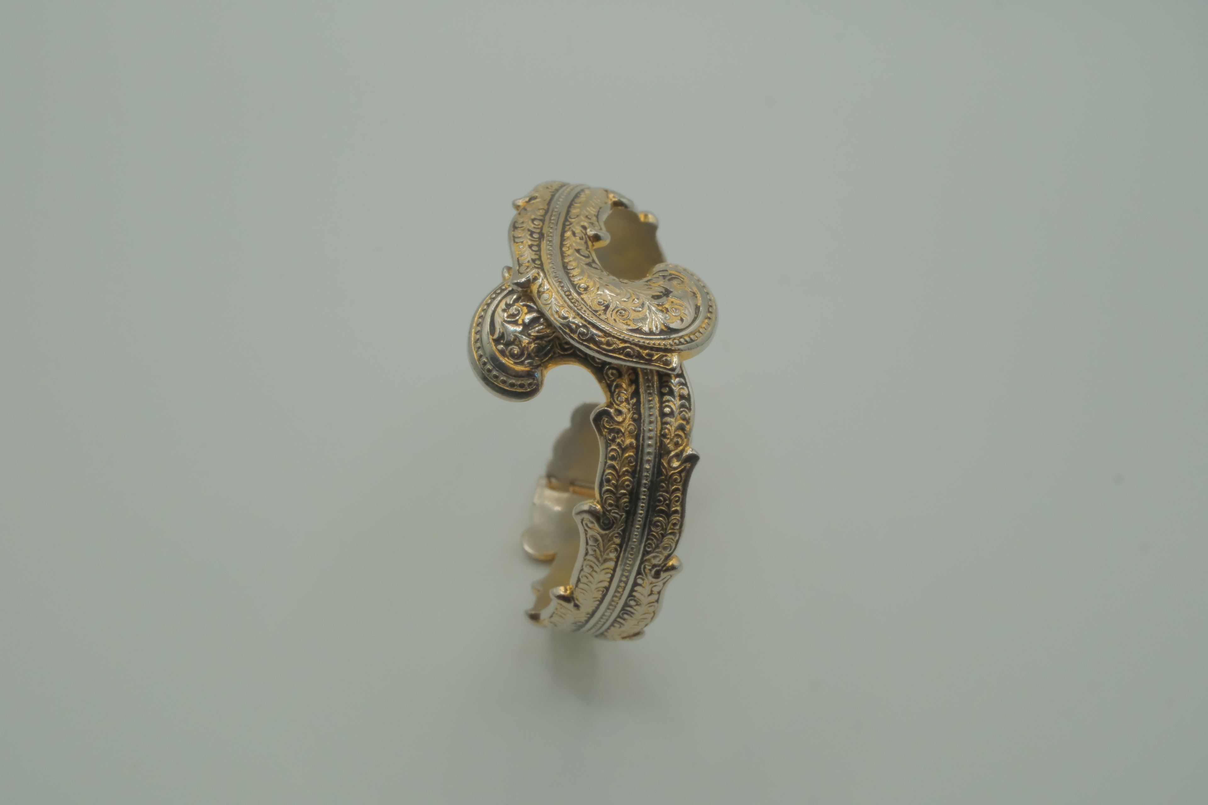 Ornate antique silver and gold-tone bypass clamper bracelet