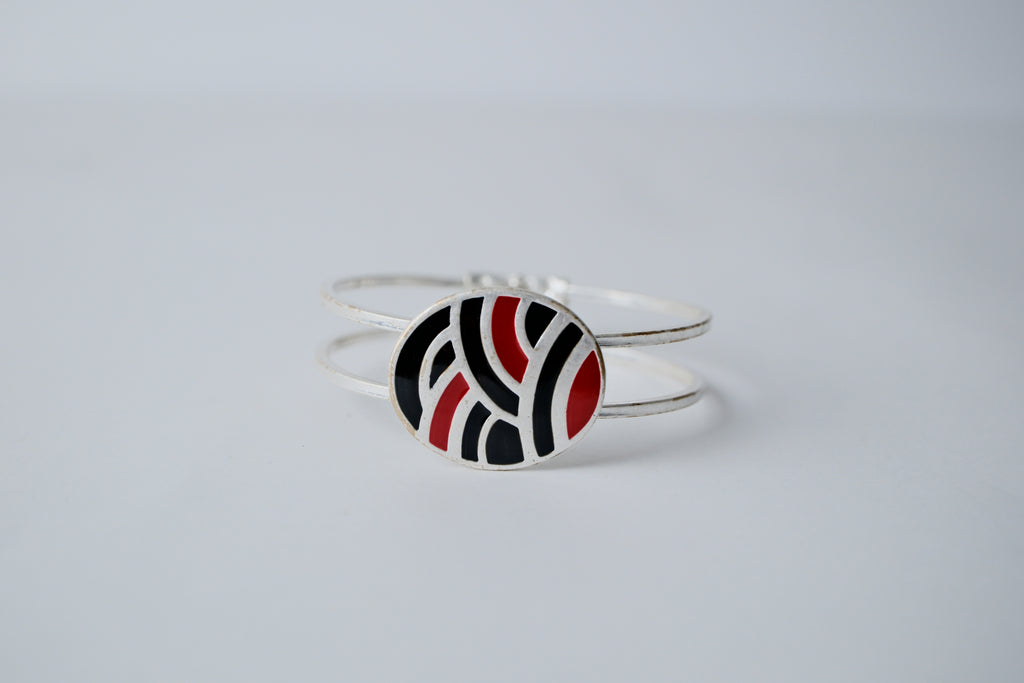 Red and black geometric pattern on a silver band