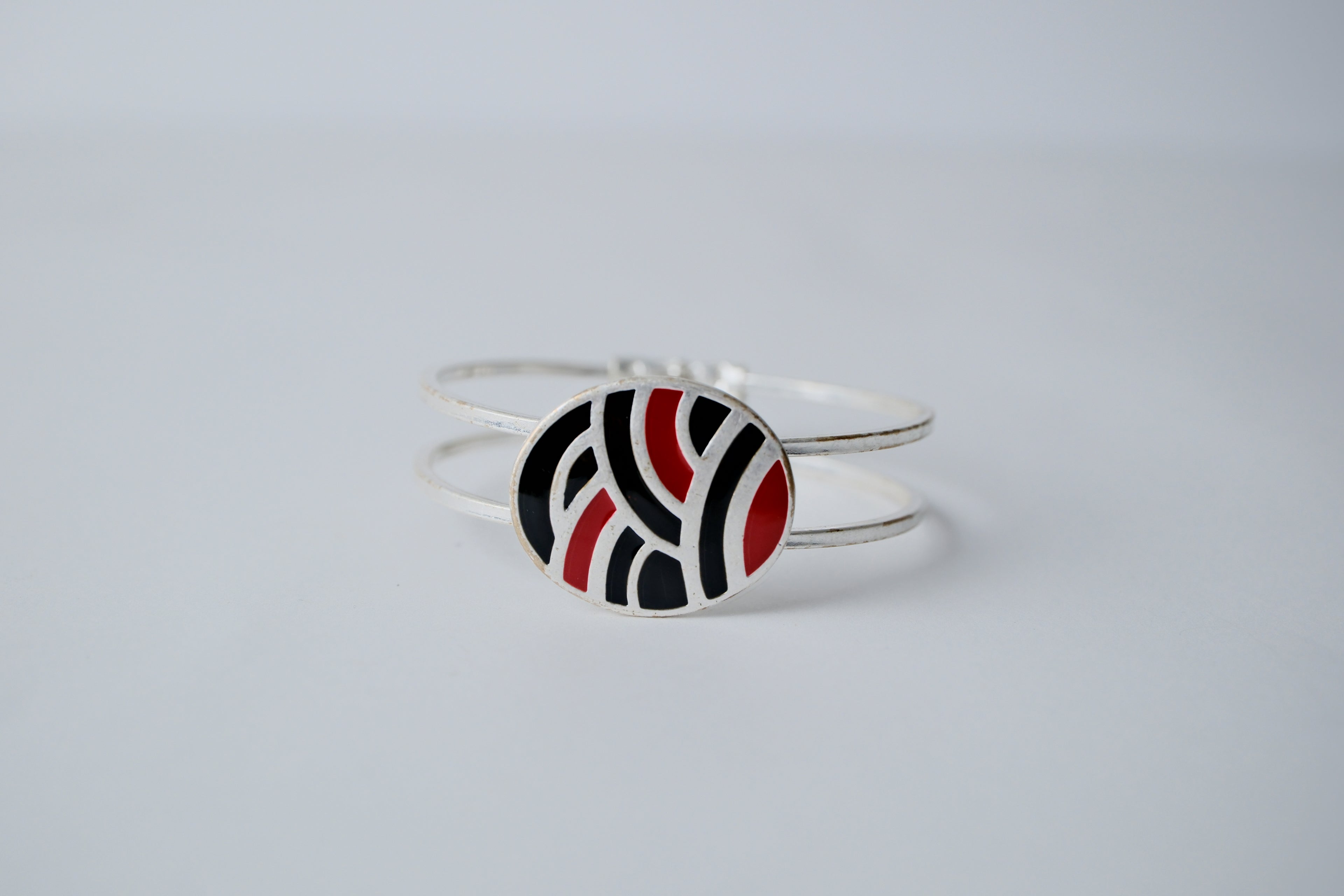 Red and black geometric pattern on a silver band