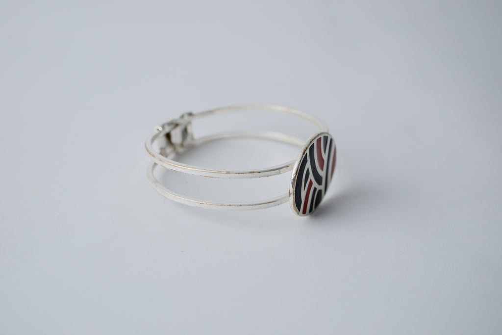 Red and black geometric pattern on a silver band