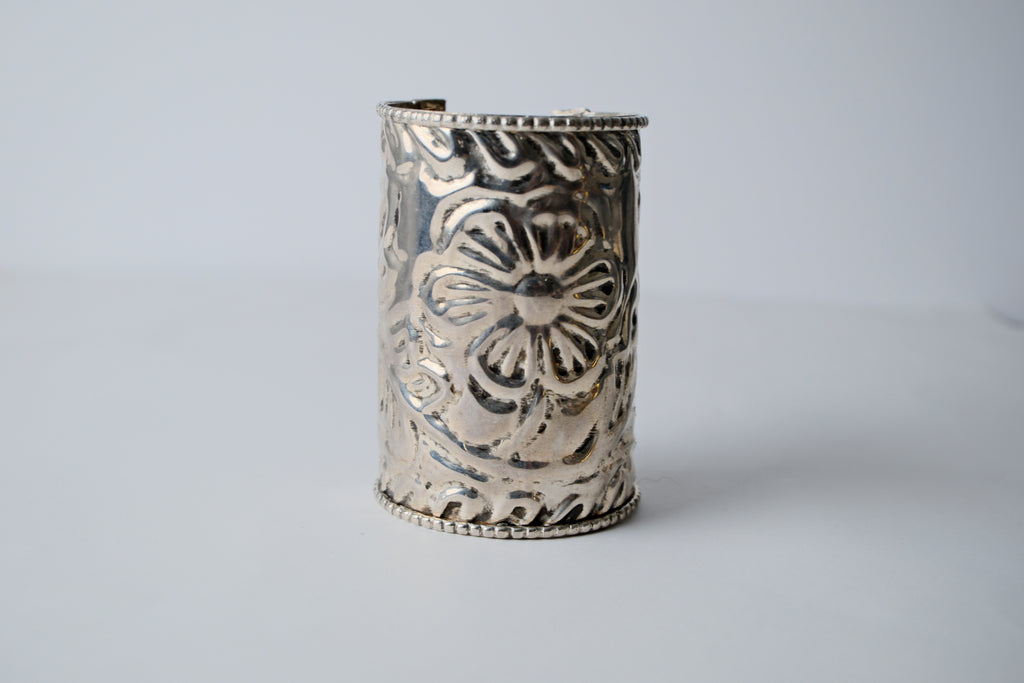 Ornate silver cuff bracelet with a floral design