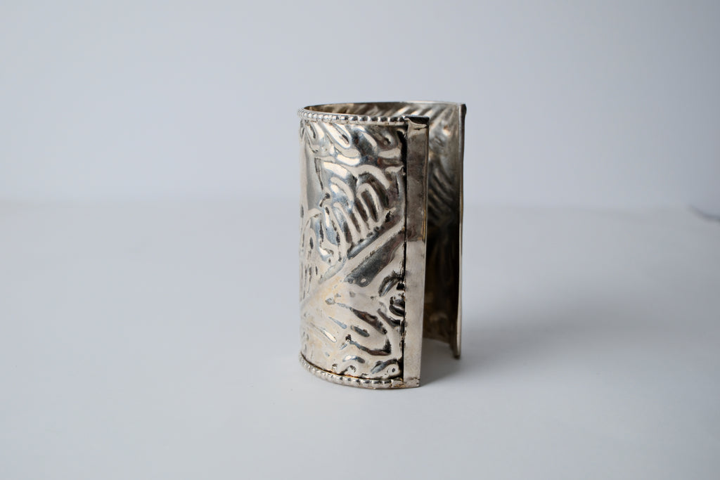 Ornate silver cuff bracelet with a floral design