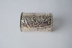 Ornate silver cuff bracelet with a floral design