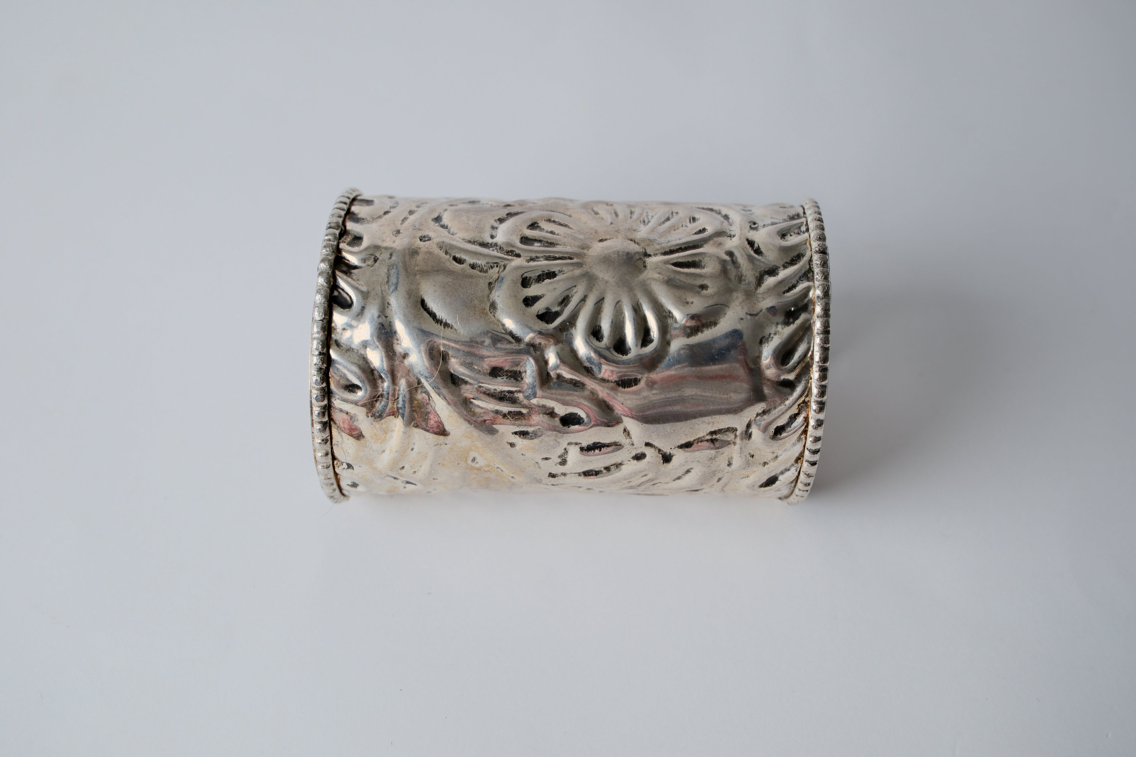 Ornate silver cuff bracelet with a floral design