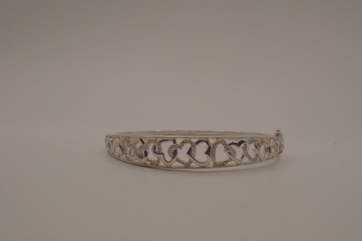 Sterling silver interlocking heart pattern hinged bangle bracelet