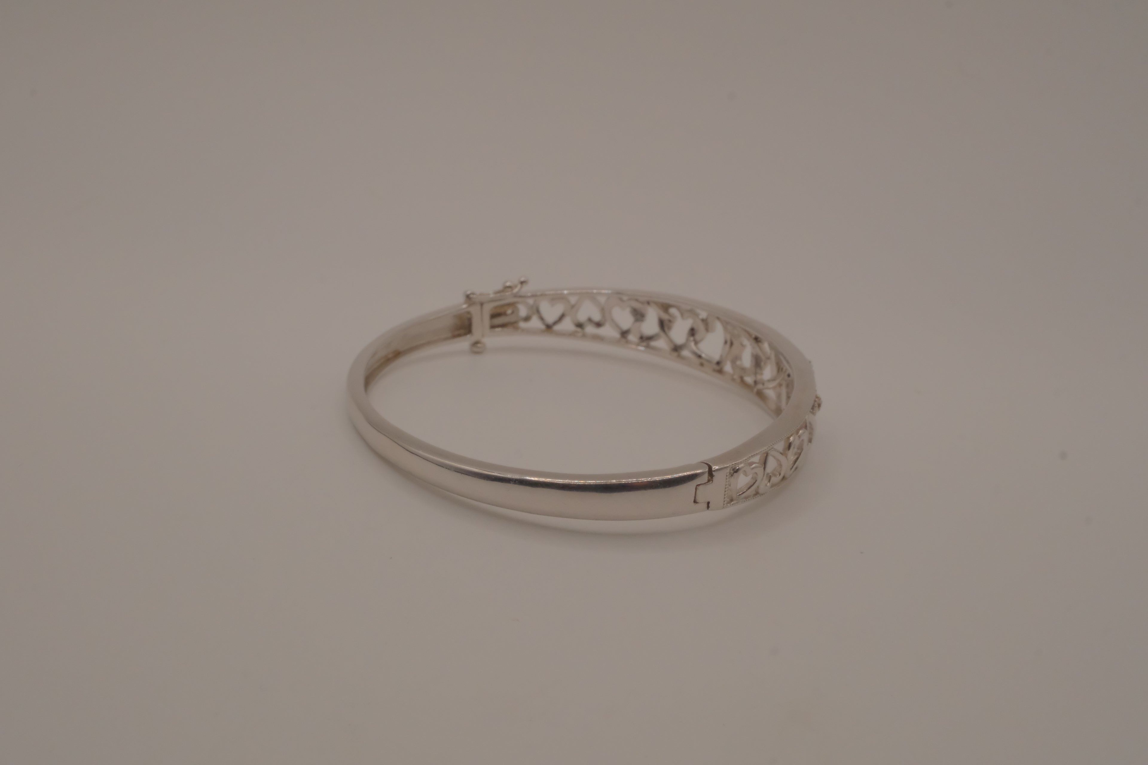 Sterling silver interlocking heart pattern hinged bangle bracelet