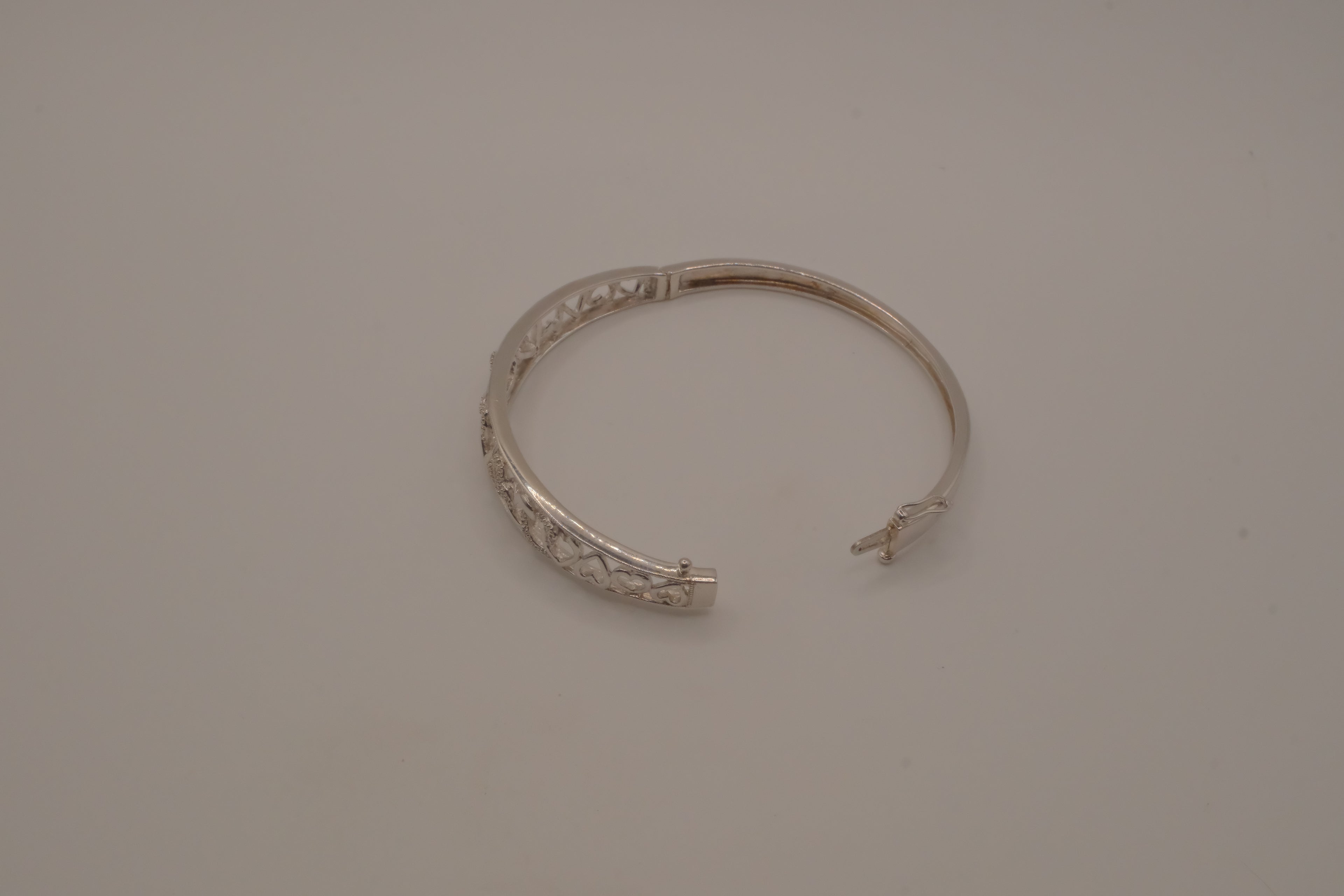 Sterling silver interlocking heart pattern hinged bangle bracelet