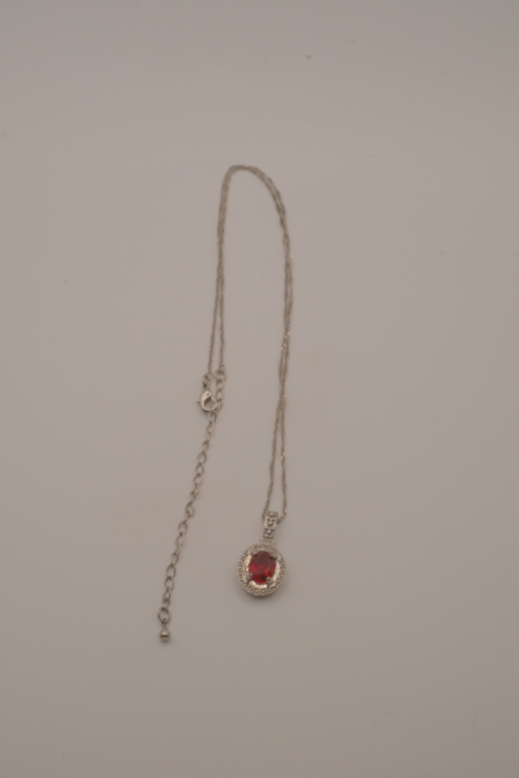 Oval-cut red gemstone halo pendant necklace