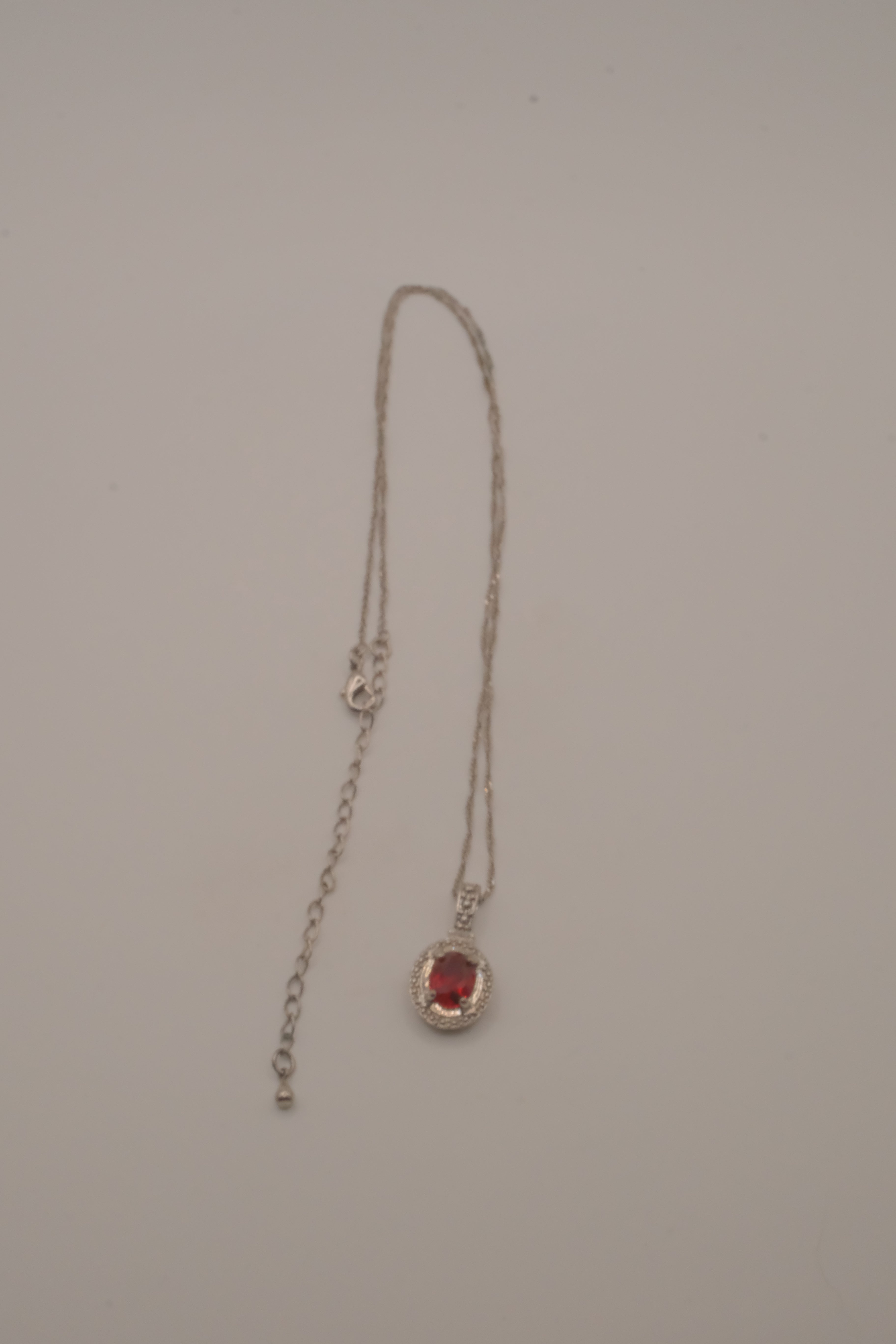 Oval-cut red gemstone halo pendant necklace