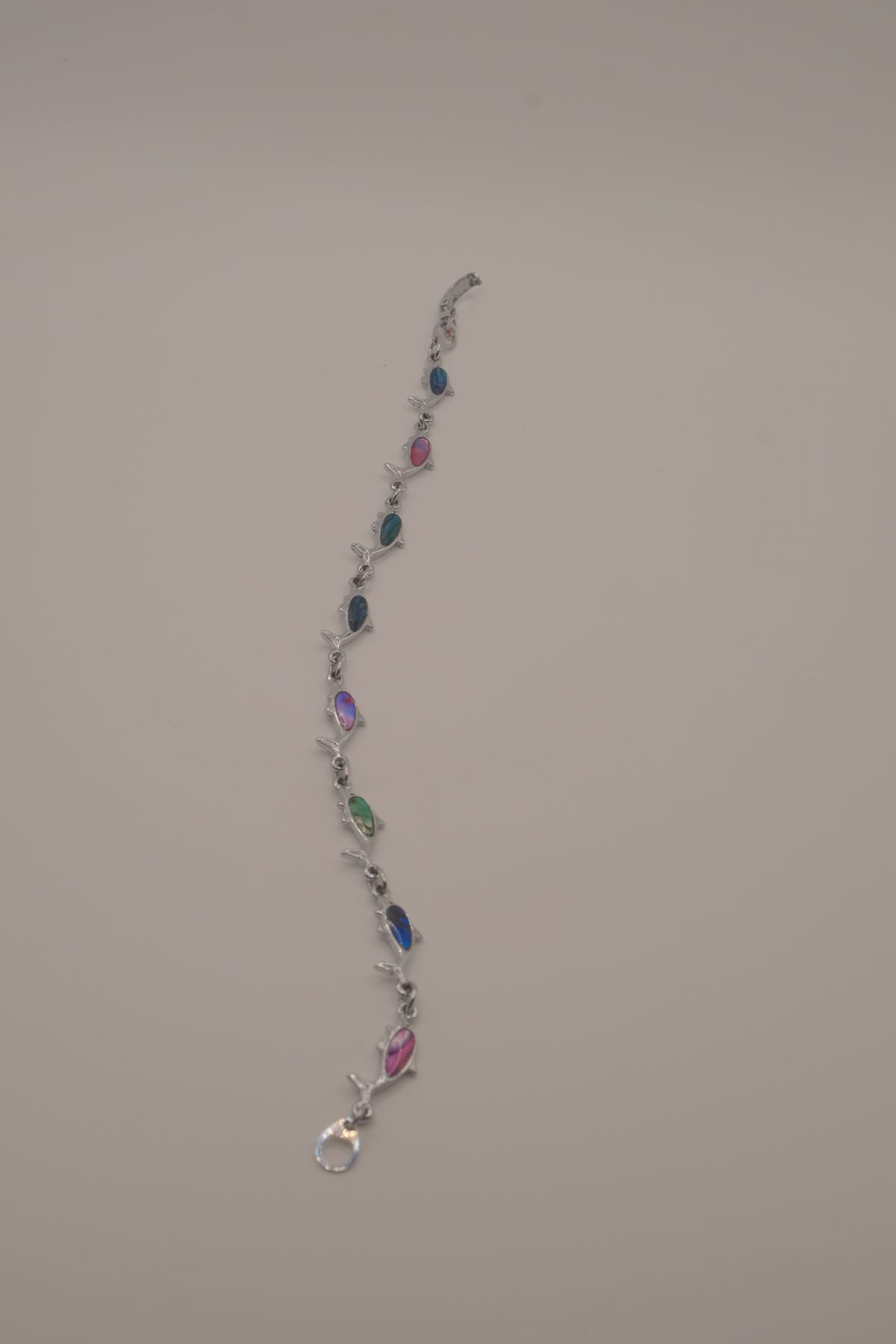Silver-tone dolphin link bracelet featuring colorful abalone shell inlays