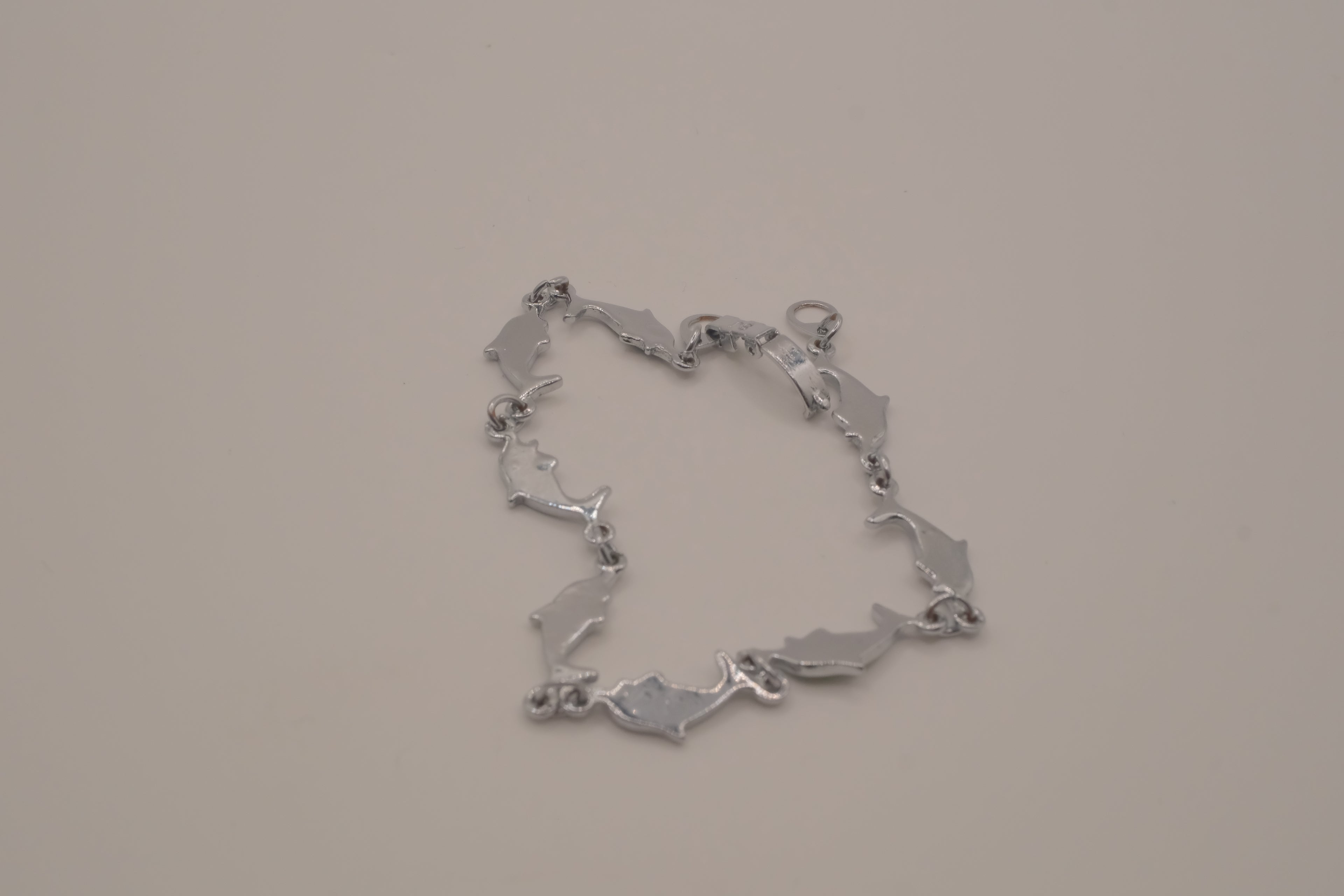 Silver-tone dolphin link bracelet featuring colorful abalone shell inlays