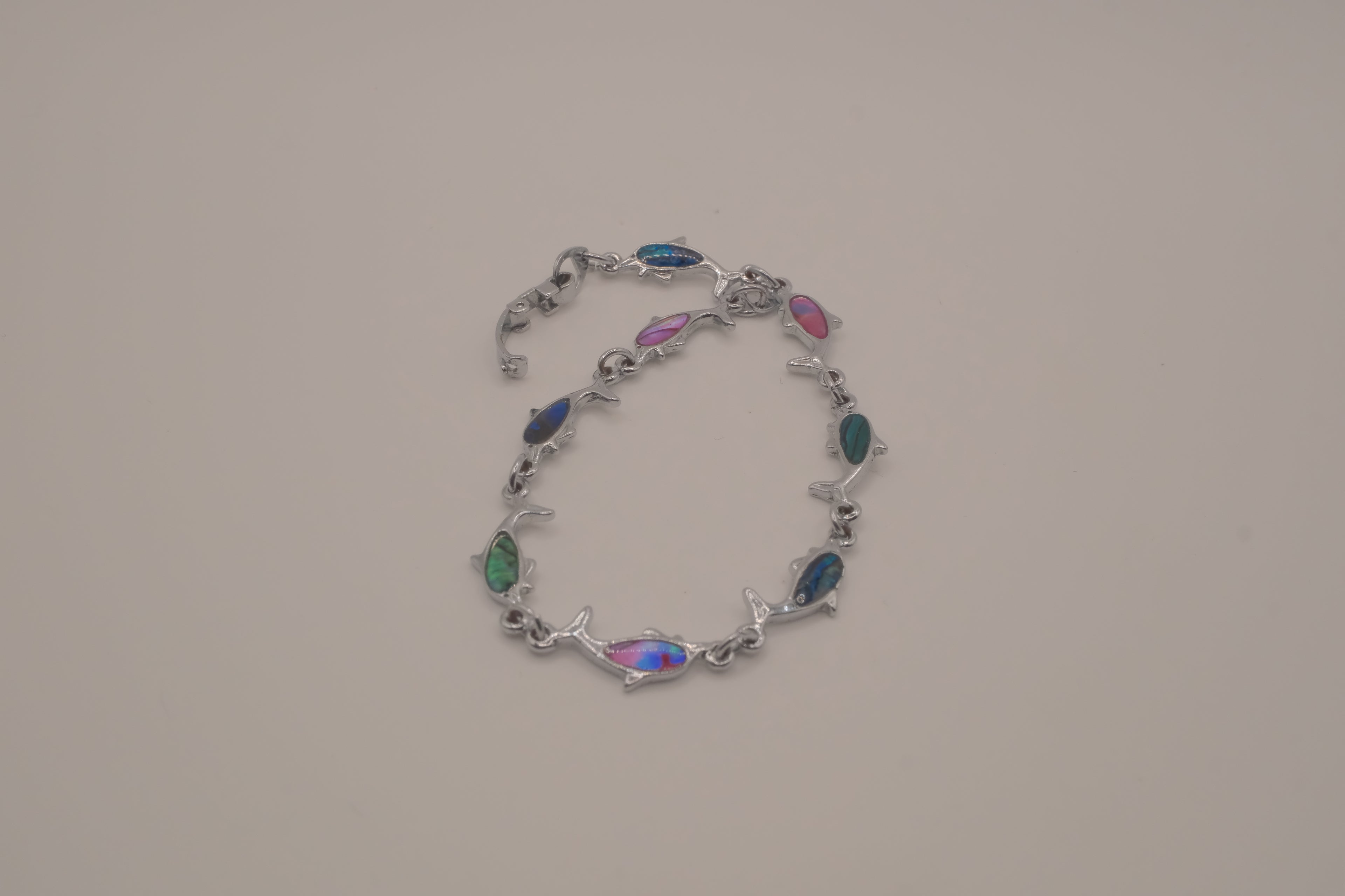 Silver-tone dolphin link bracelet featuring colorful abalone shell inlays