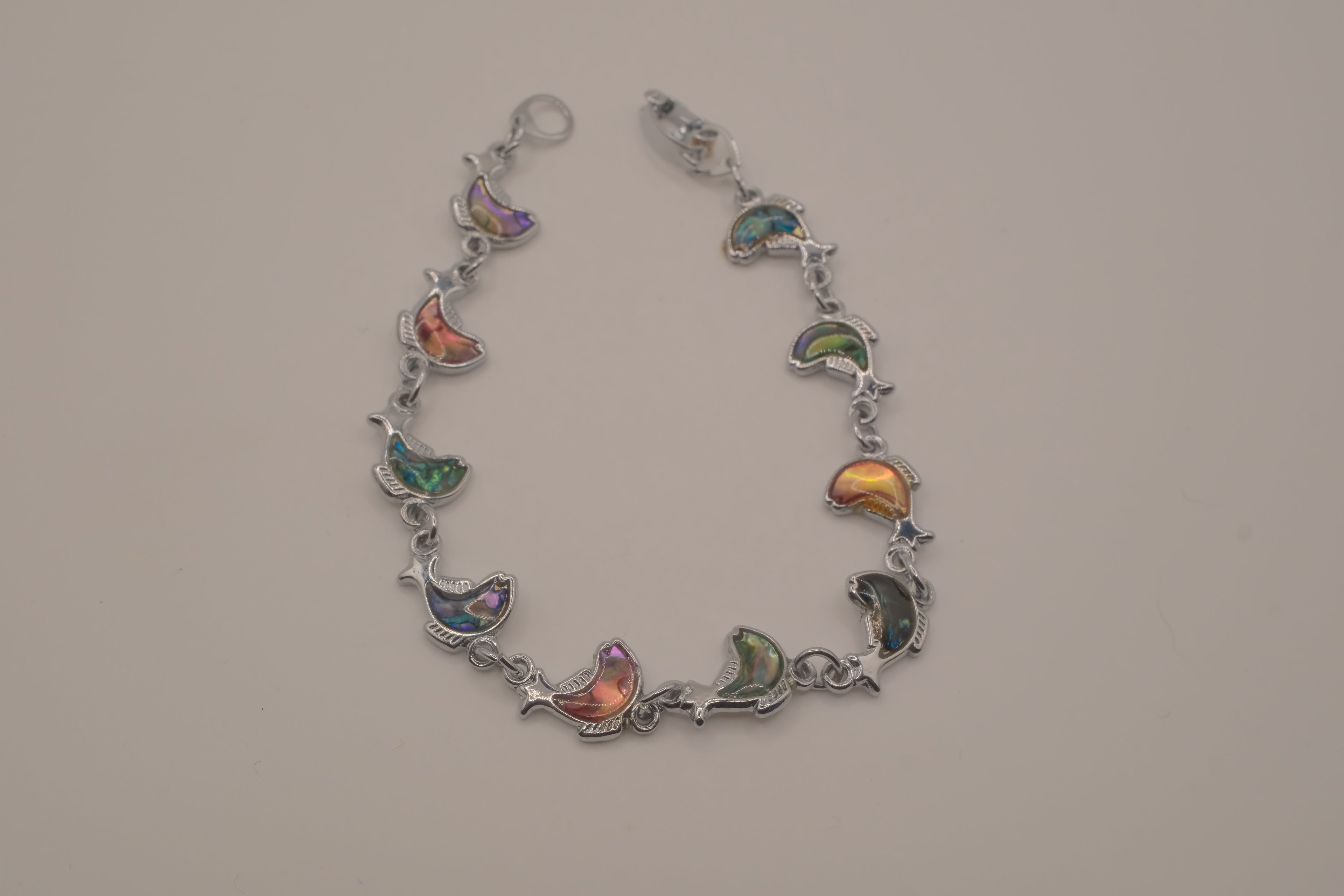 Silver-tone abalone dolphin as crescent motifs link bracelet