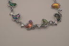 Silver-tone abalone dolphin as crescent motifs link bracelet