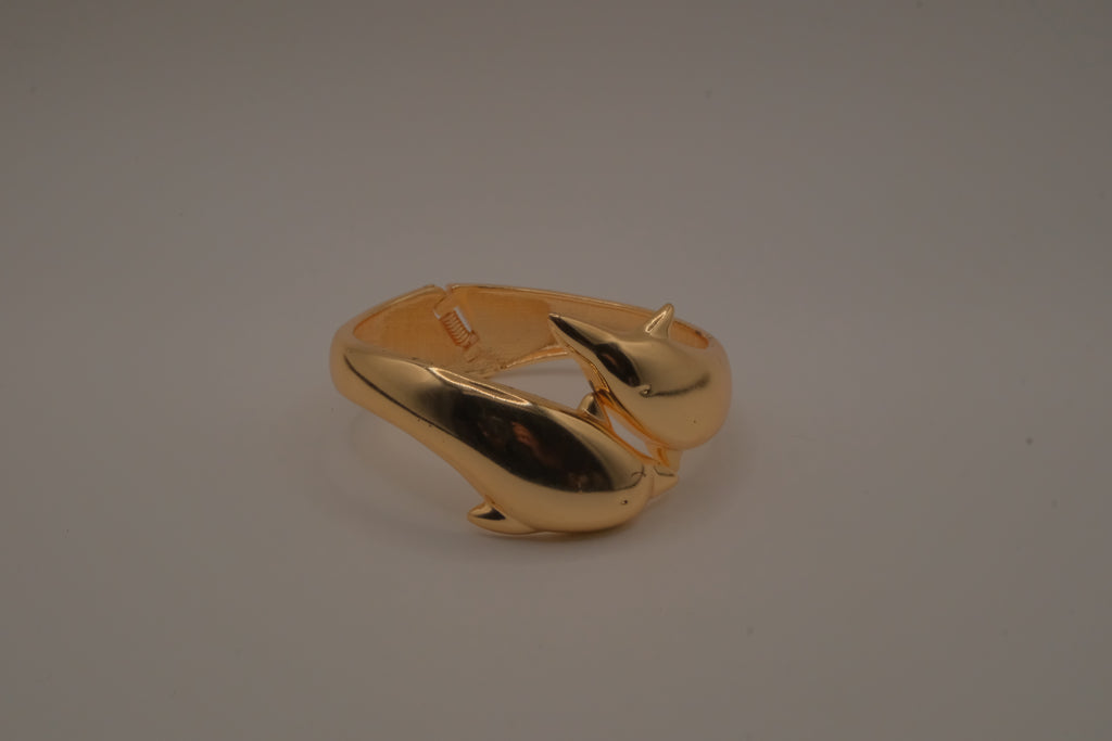 Gold tone two interlocking dolphins cuff bracelet