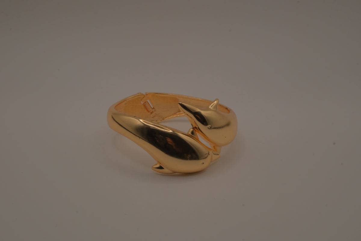 Gold tone two interlocking dolphins cuff bracelet