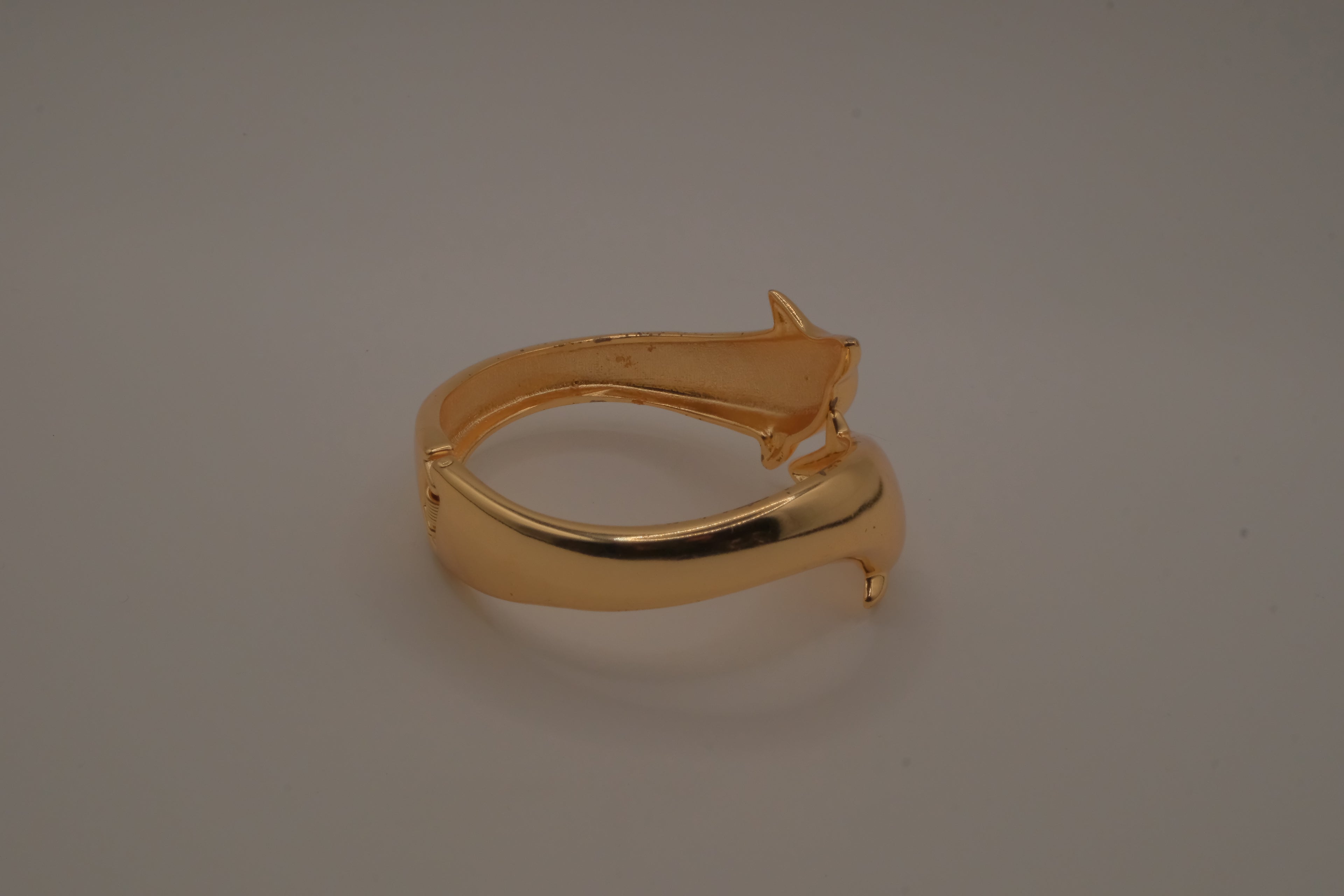 Gold tone two interlocking dolphins cuff bracelet