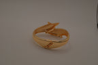 Gold tone two interlocking dolphins cuff bracelet