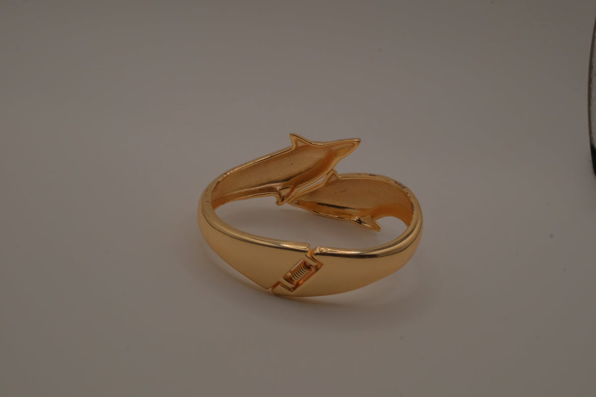 Gold tone two interlocking dolphins cuff bracelet