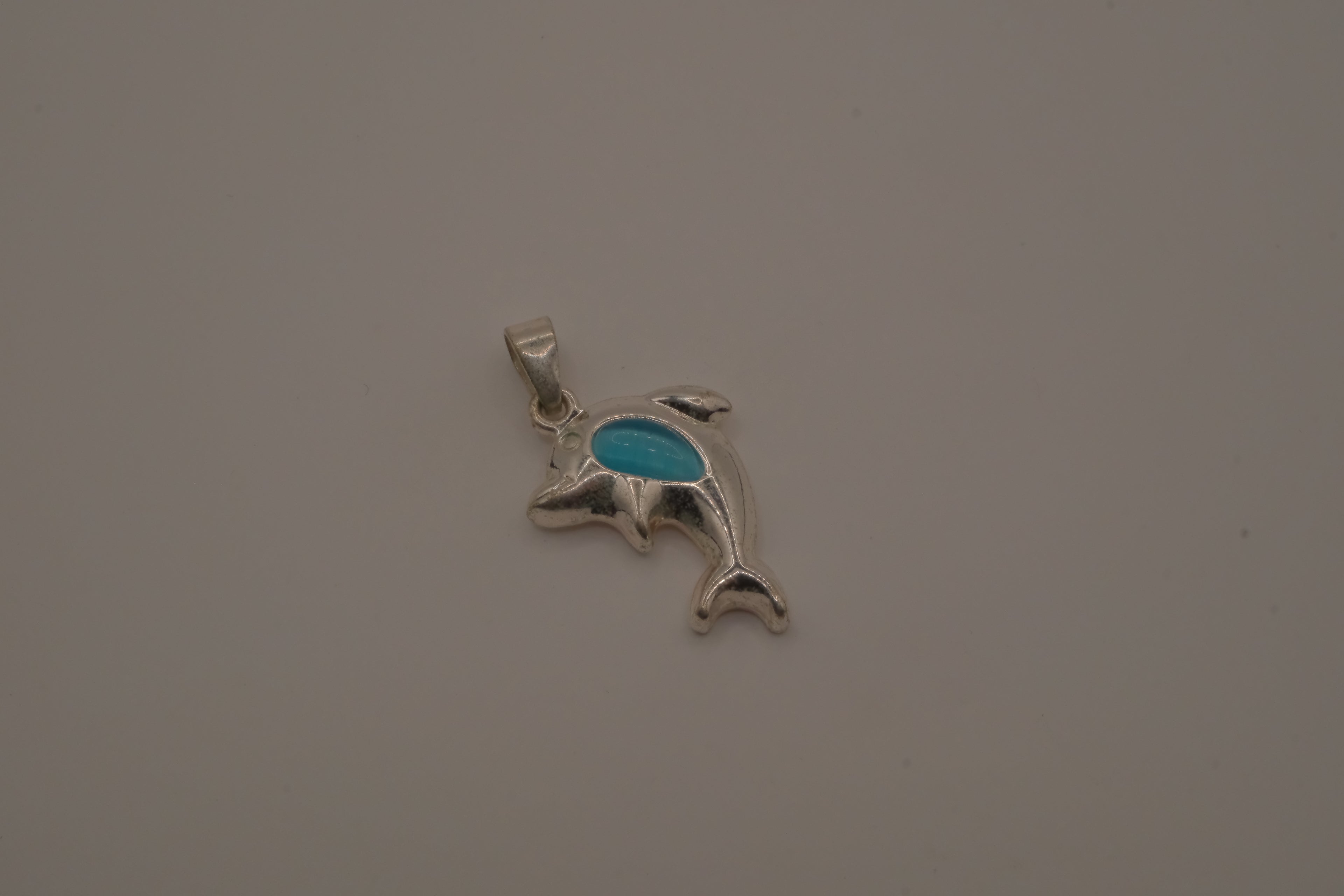 Dolphin pendant inlaid with vibrant blue stone