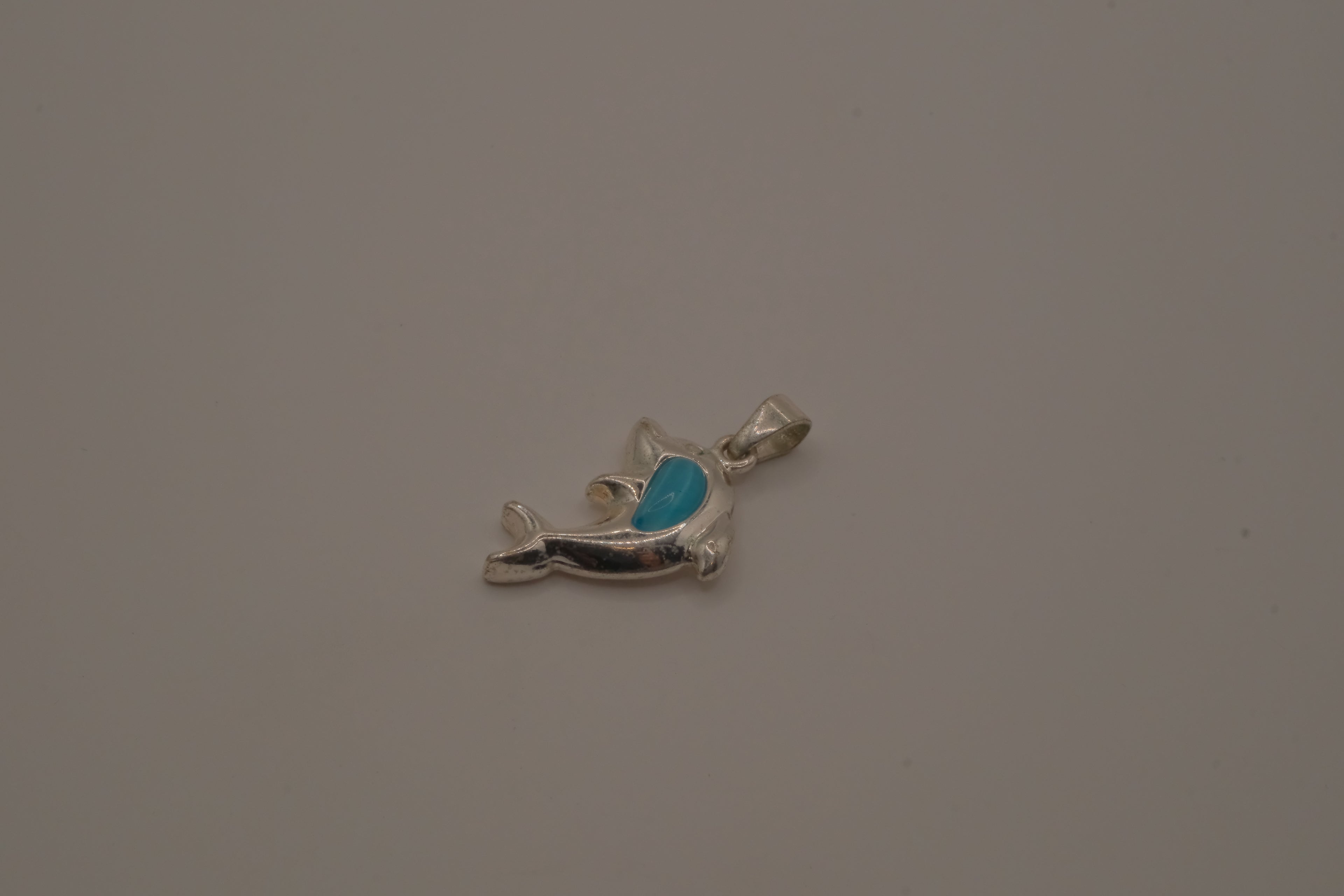 Dolphin pendant inlaid with vibrant blue stone