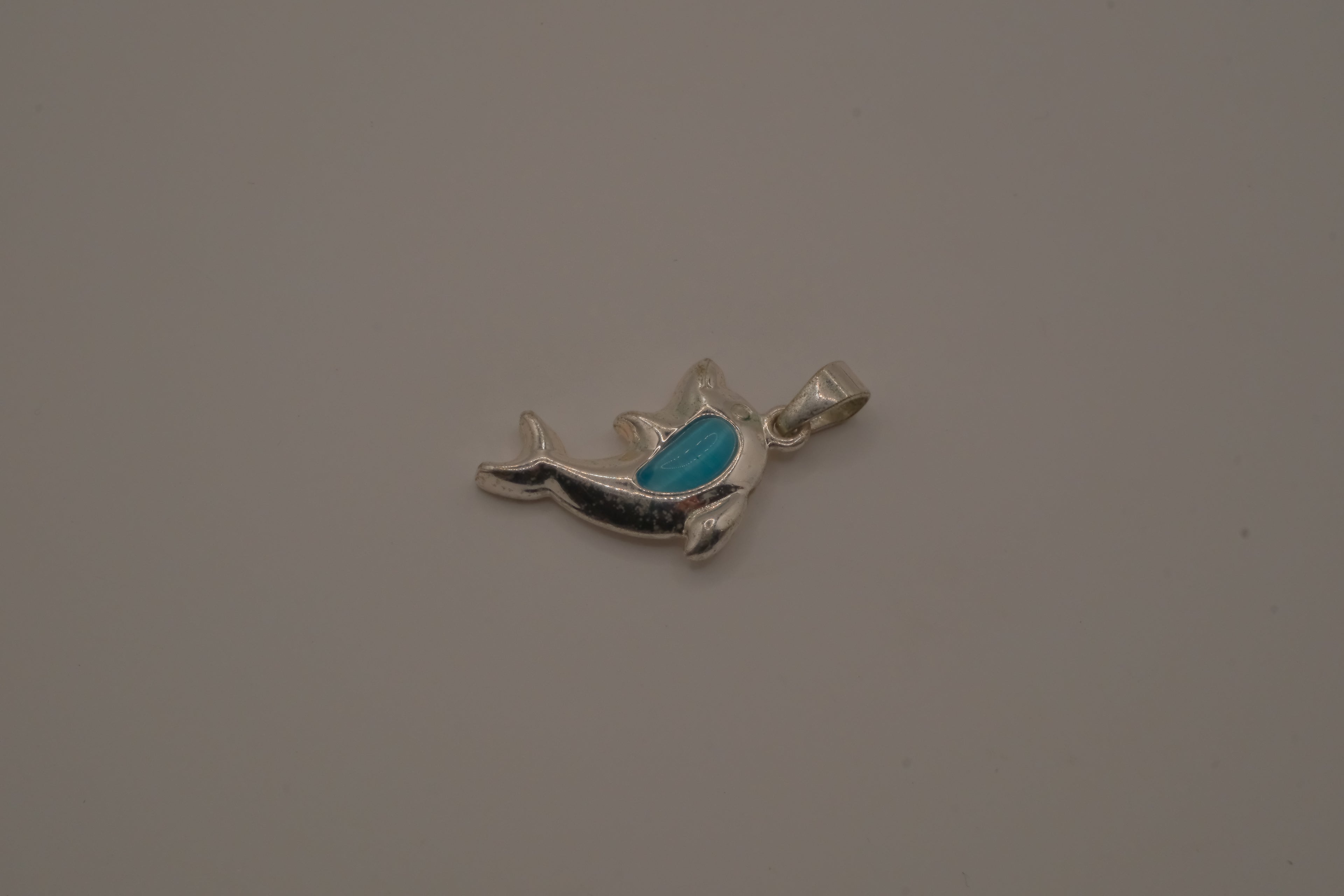 Dolphin pendant inlaid with vibrant blue stone