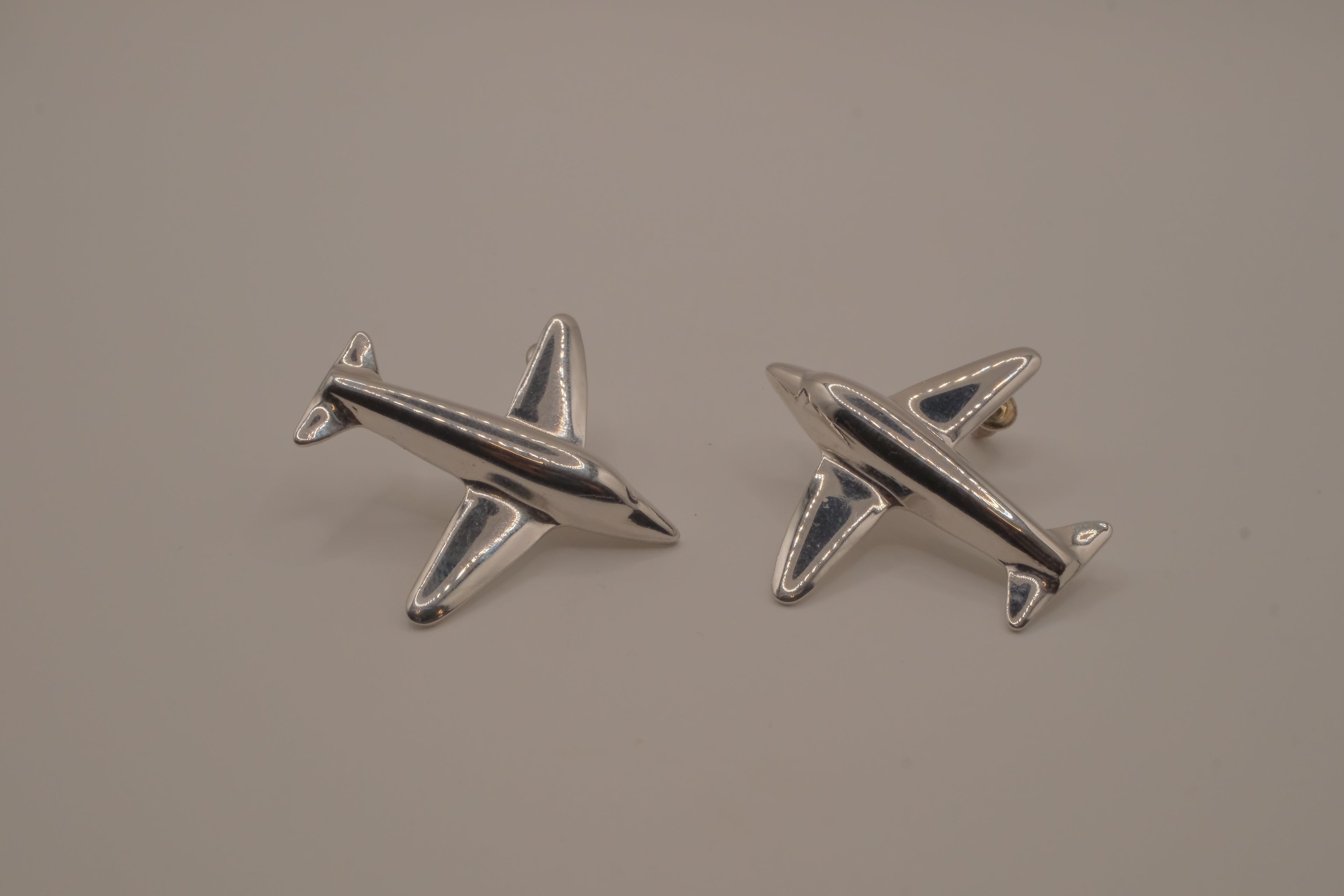 Silver-toned jet airplane-shaped earrings
