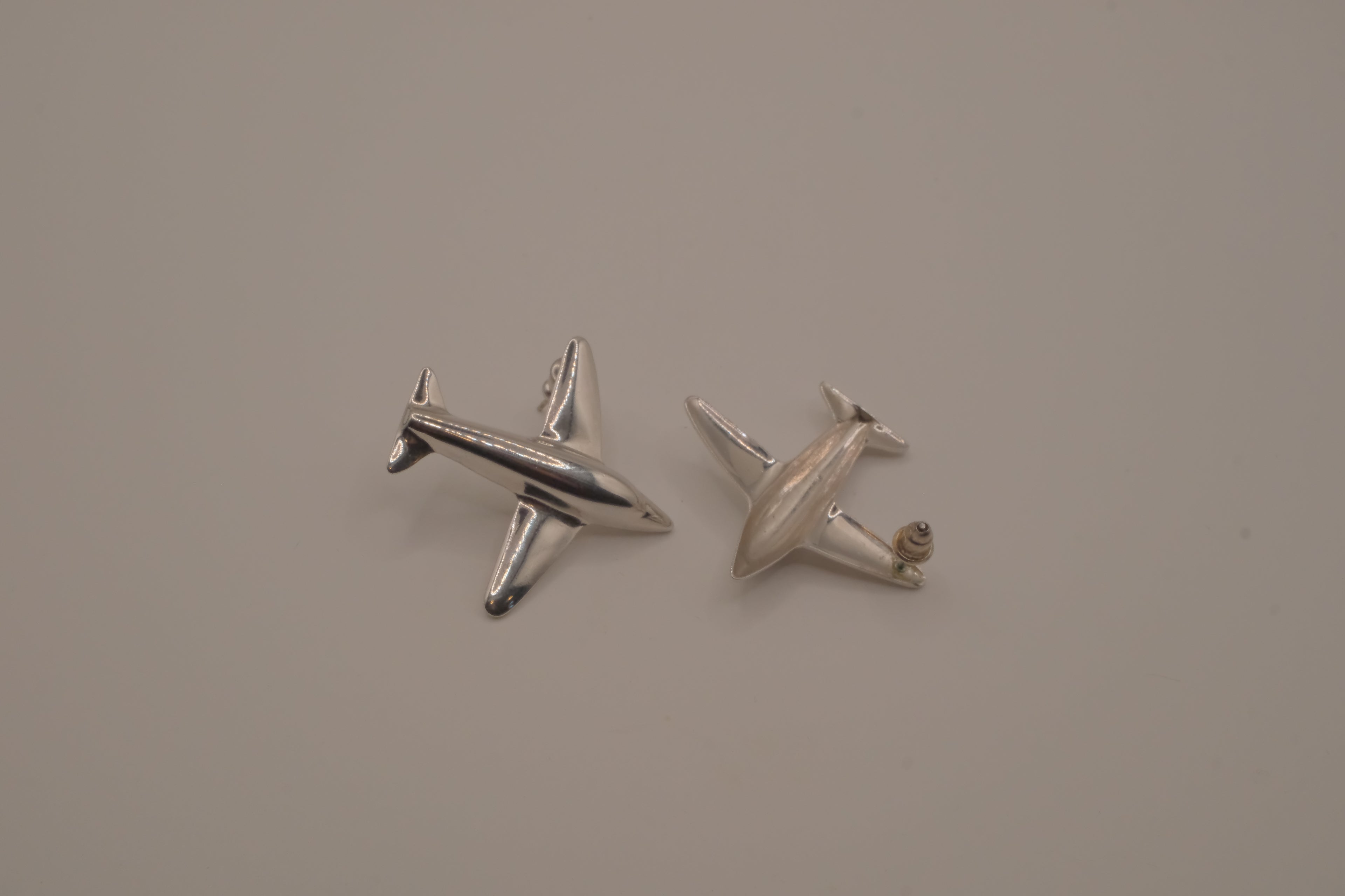 Silver-toned jet airplane-shaped earrings