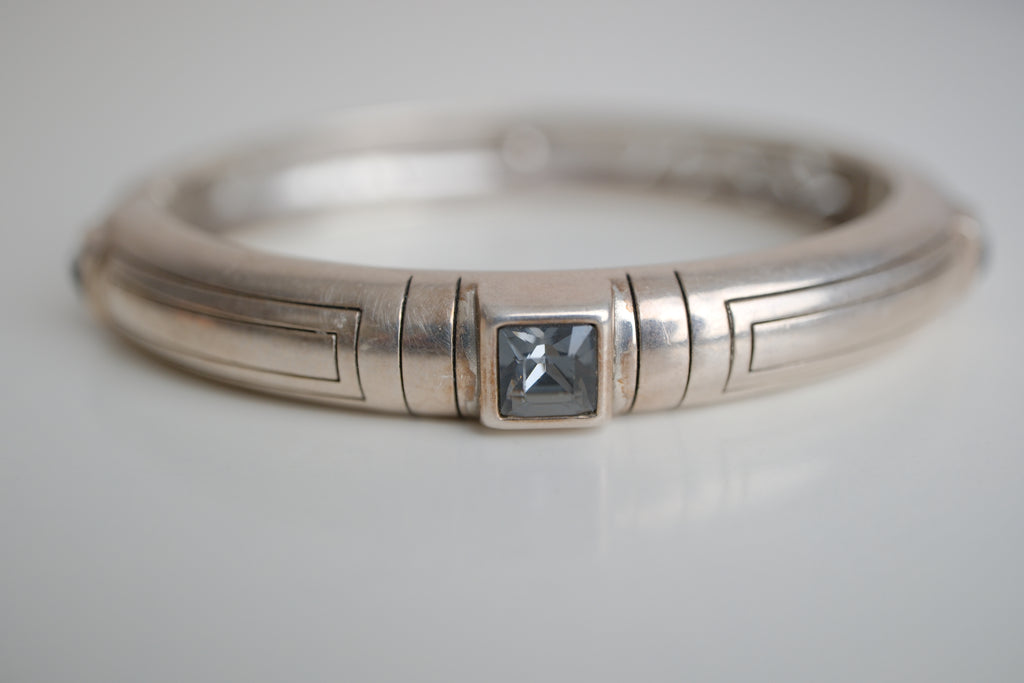 Silver toned patterned bangle with square grey stones