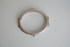 Silver toned patterned bangle with square grey stones