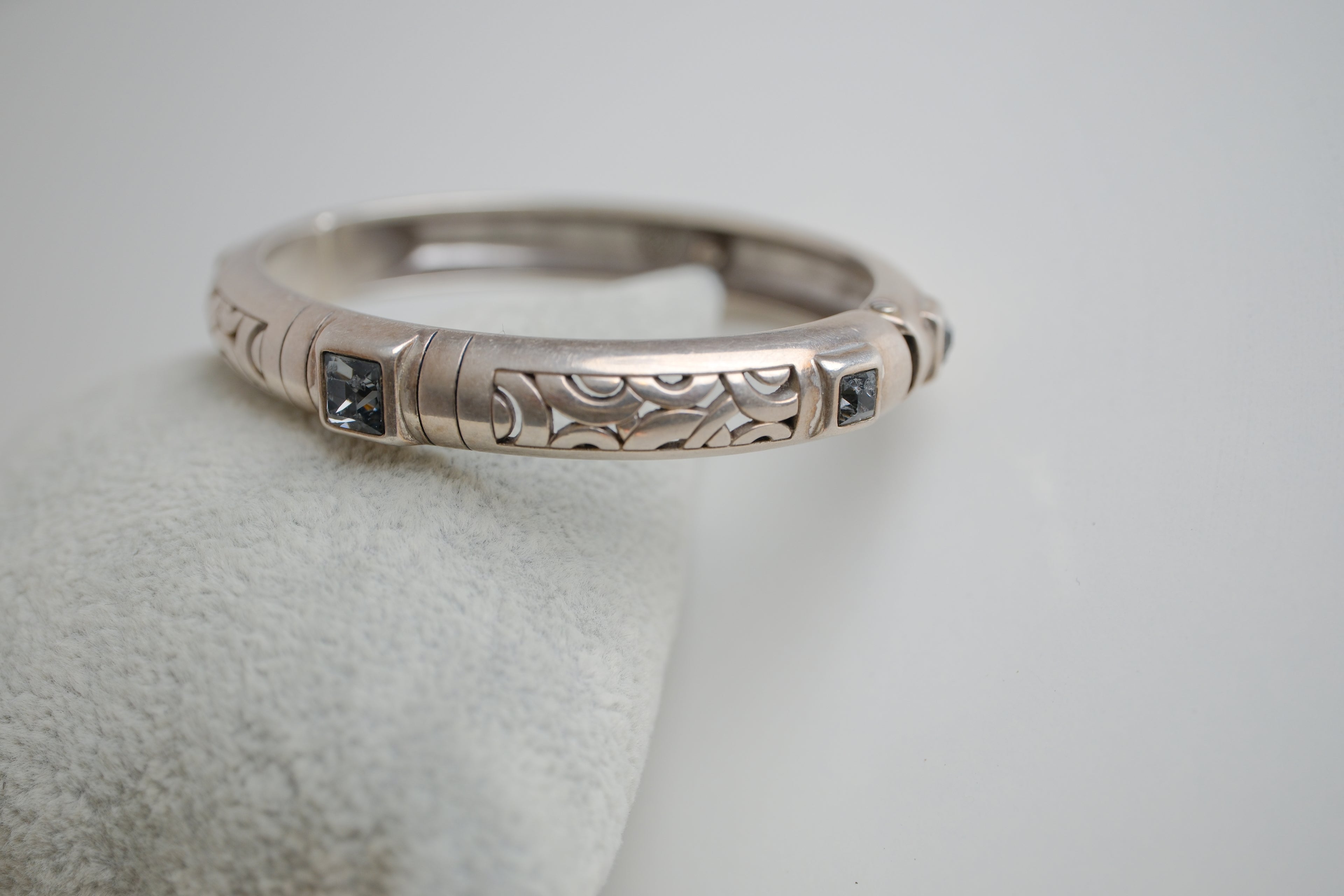 Silver toned patterned bangle with square grey stones