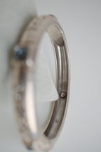 Silver toned patterned bangle with square grey stones