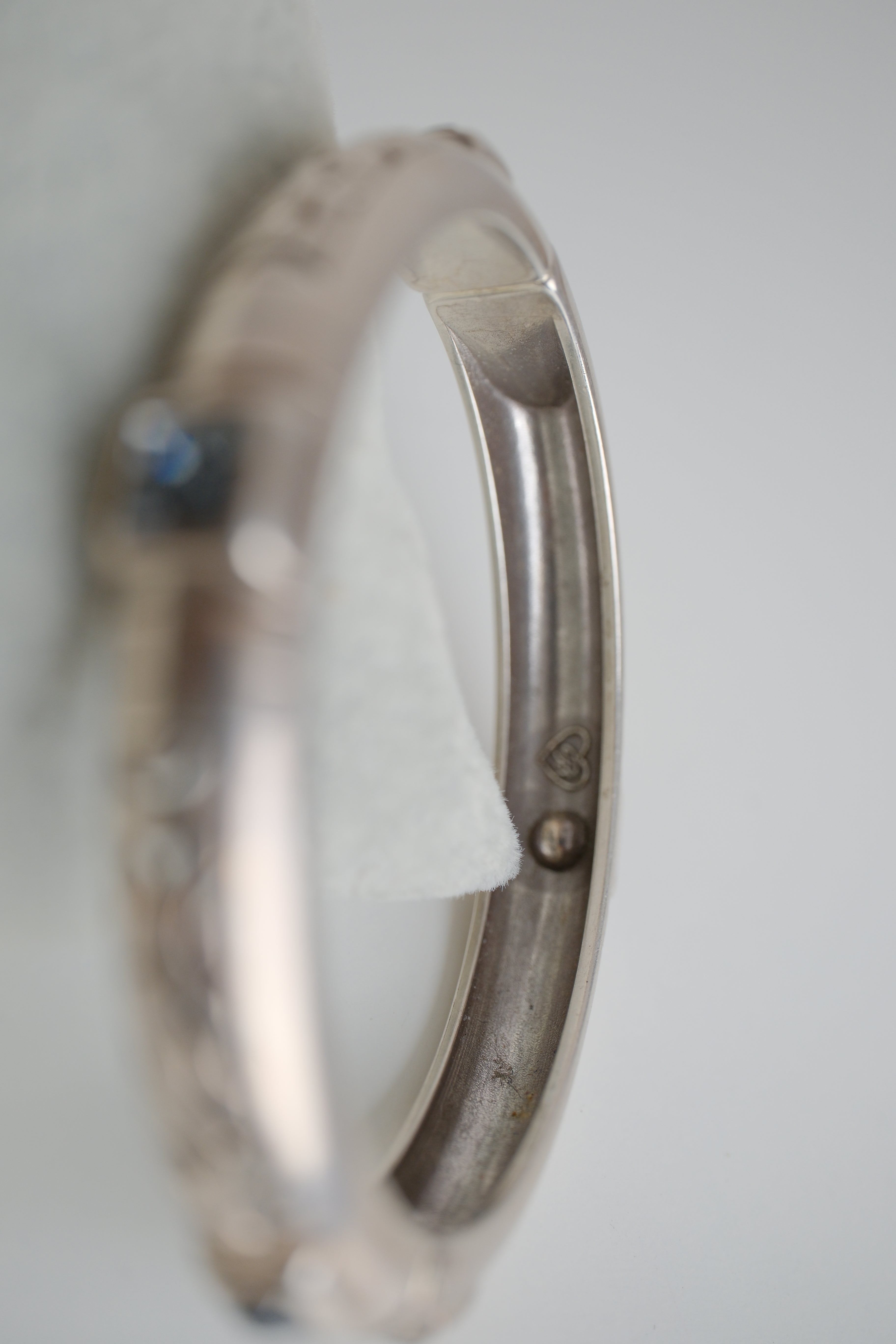 Silver toned patterned bangle with square grey stones