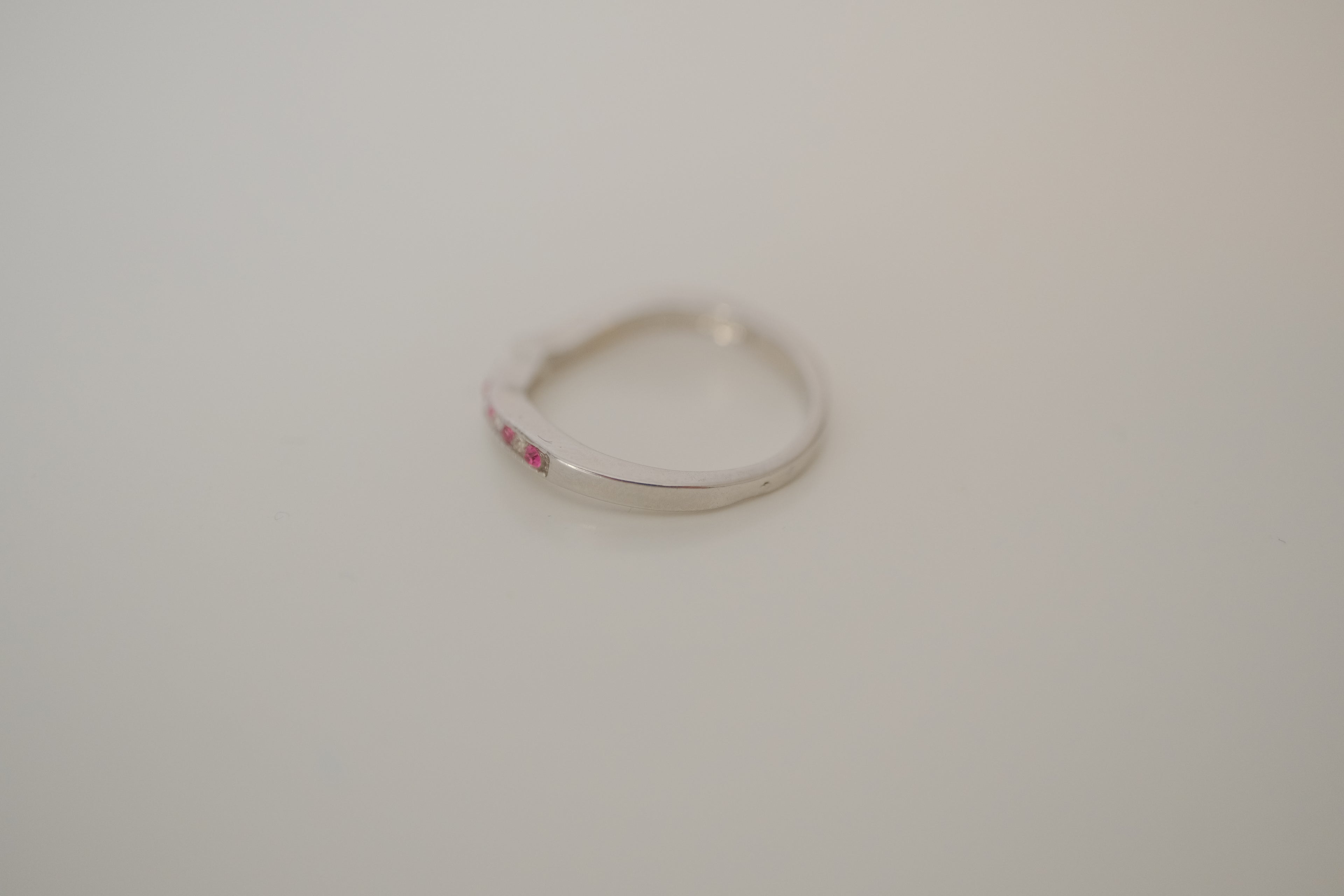 Silver tone pink and white curved "wishbone" ring