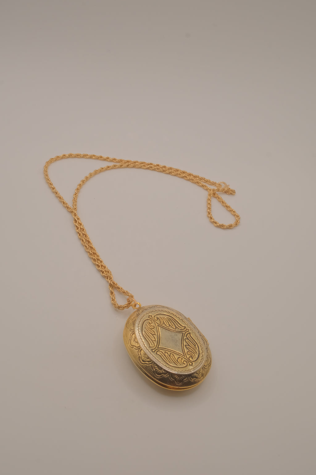 Vintage oval gold locket necklace with  Raised floral design