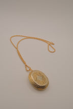 Vintage oval gold locket necklace with  Raised floral design