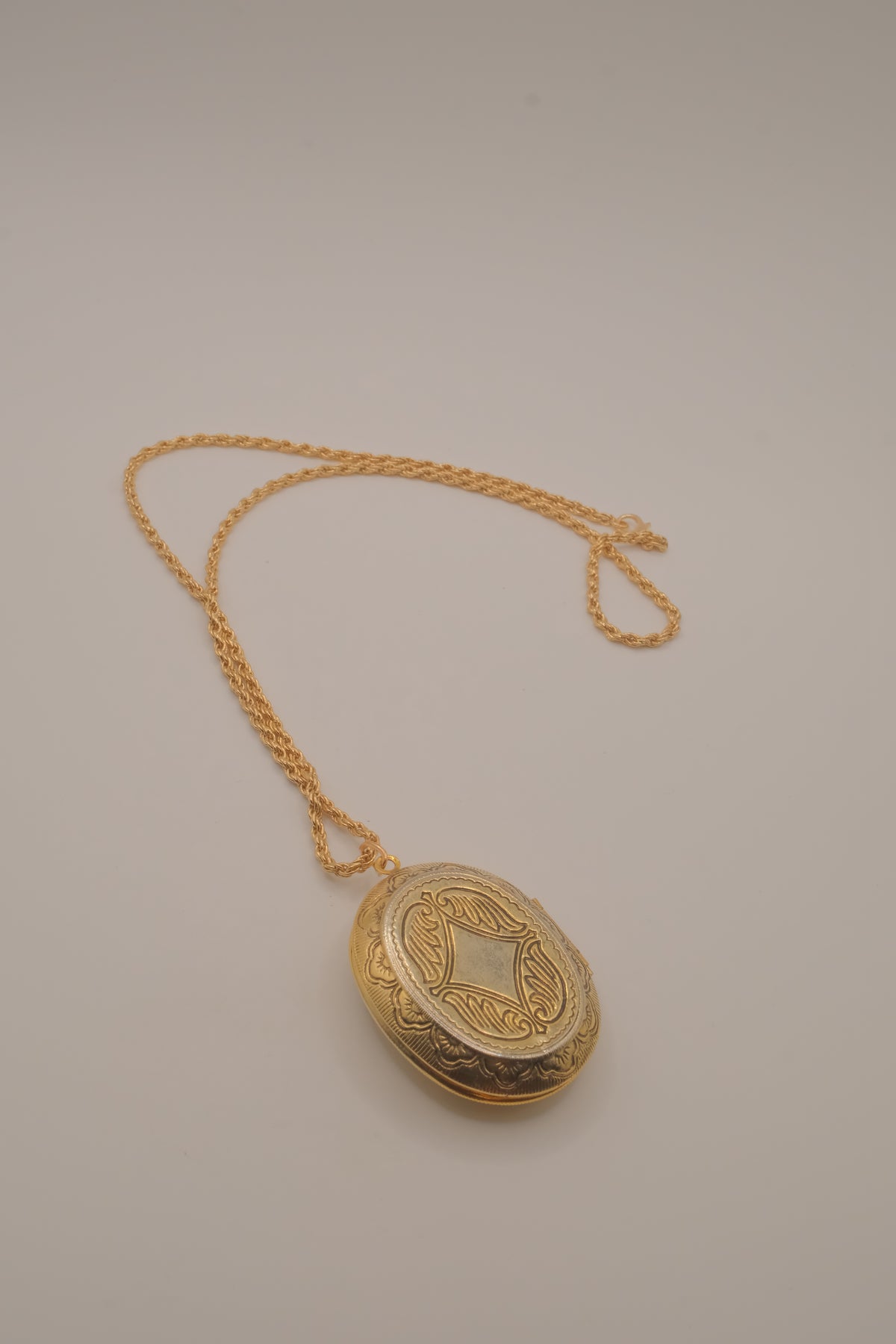 Vintage oval gold locket necklace with  Raised floral design