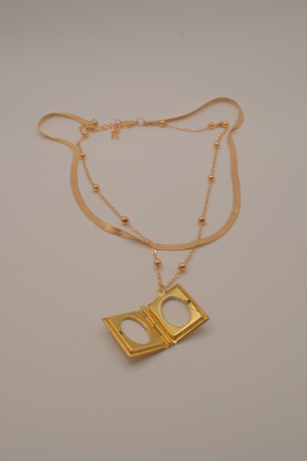 Layered Sleek and beaded chain with gold book locket pendant