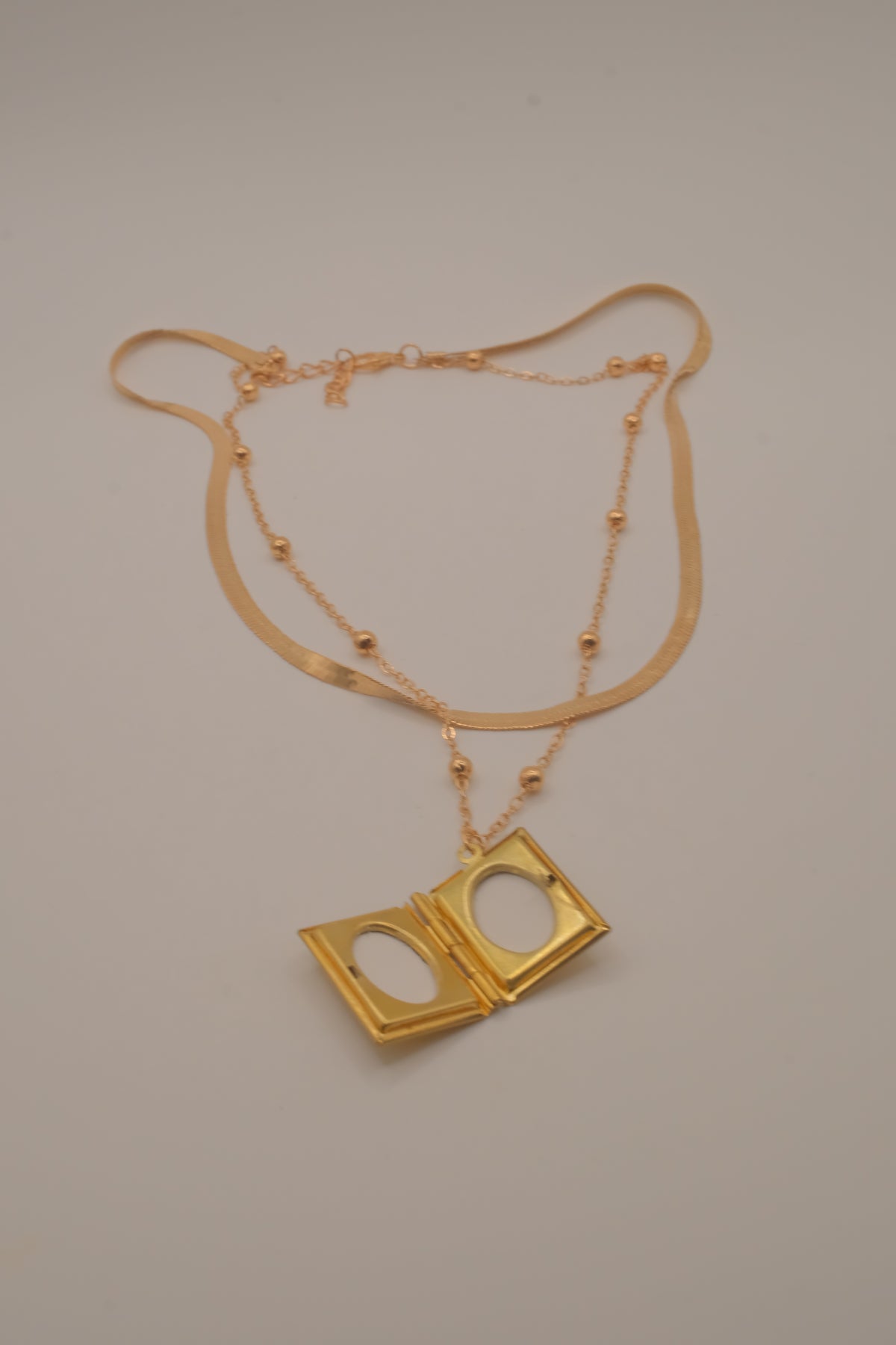 Layered Sleek and beaded chain with gold book locket pendant