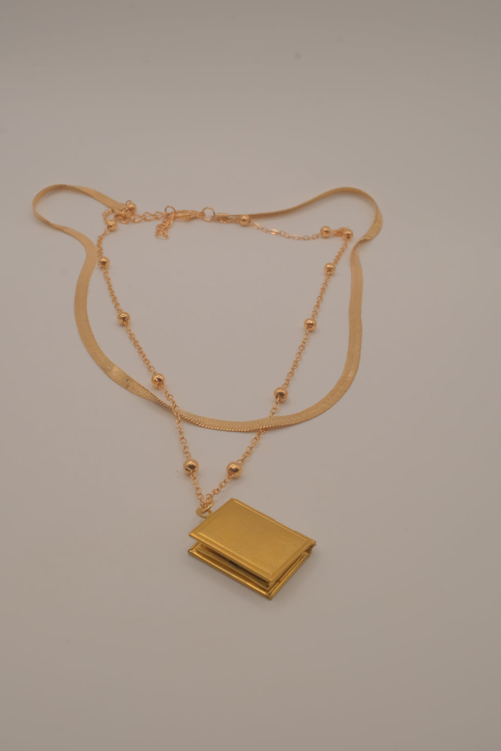 Layered Sleek and beaded chain with gold book locket pendant