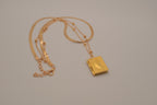 Layered Sleek and beaded chain with gold book locket pendant