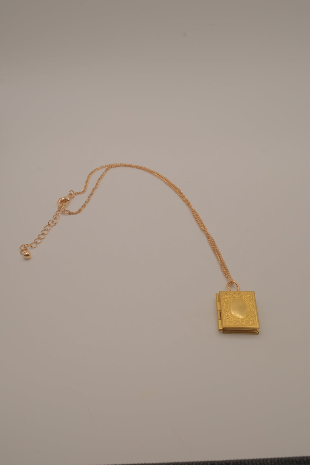 Vintage-style gold book locket pendant on gold link chain