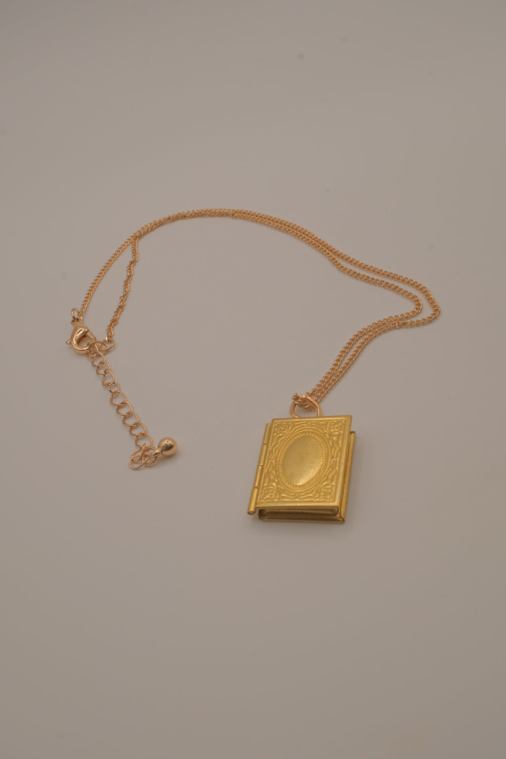 Vintage-style gold book locket pendant on gold link chain
