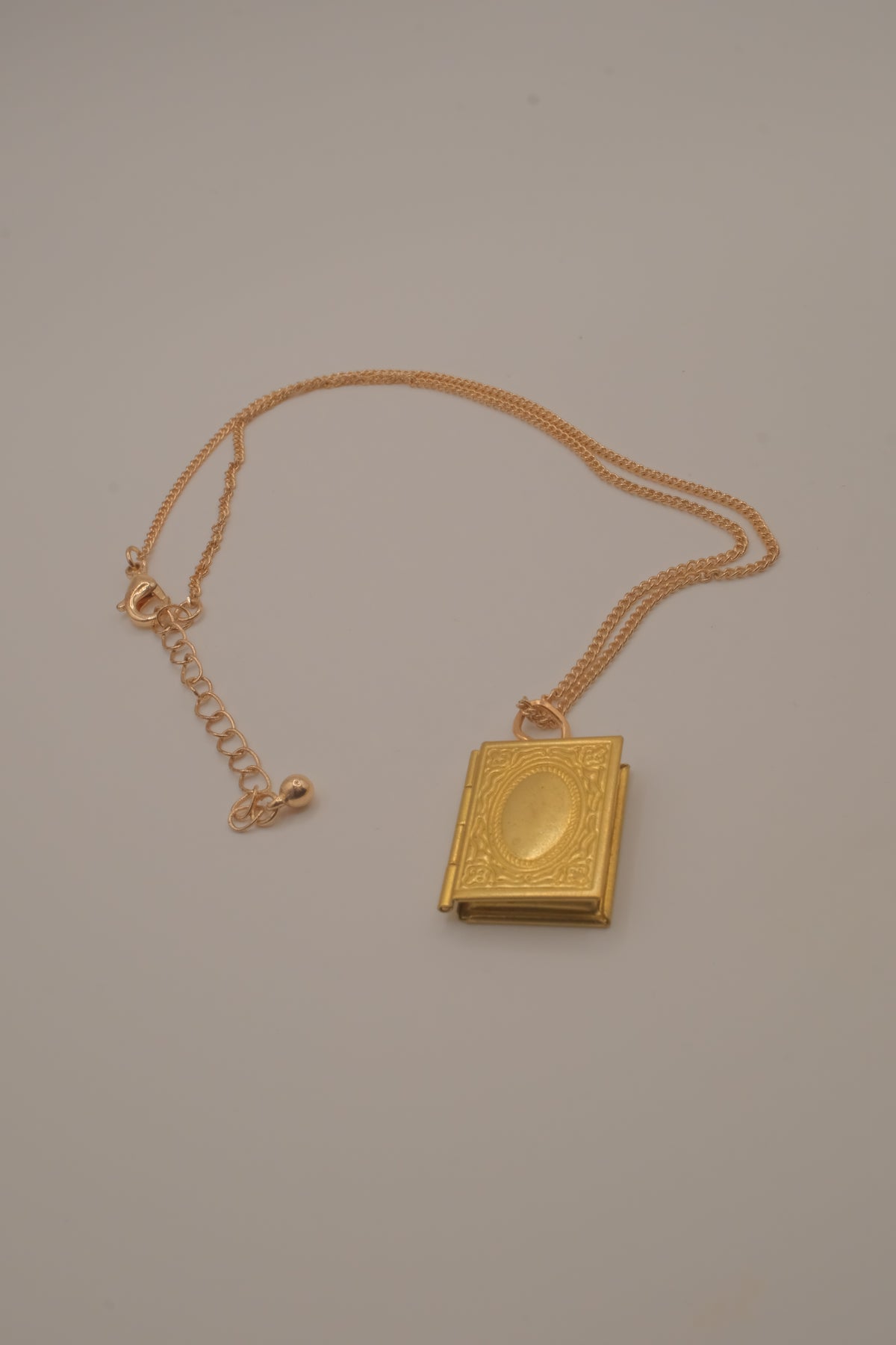 Vintage-style gold book locket pendant on gold link chain