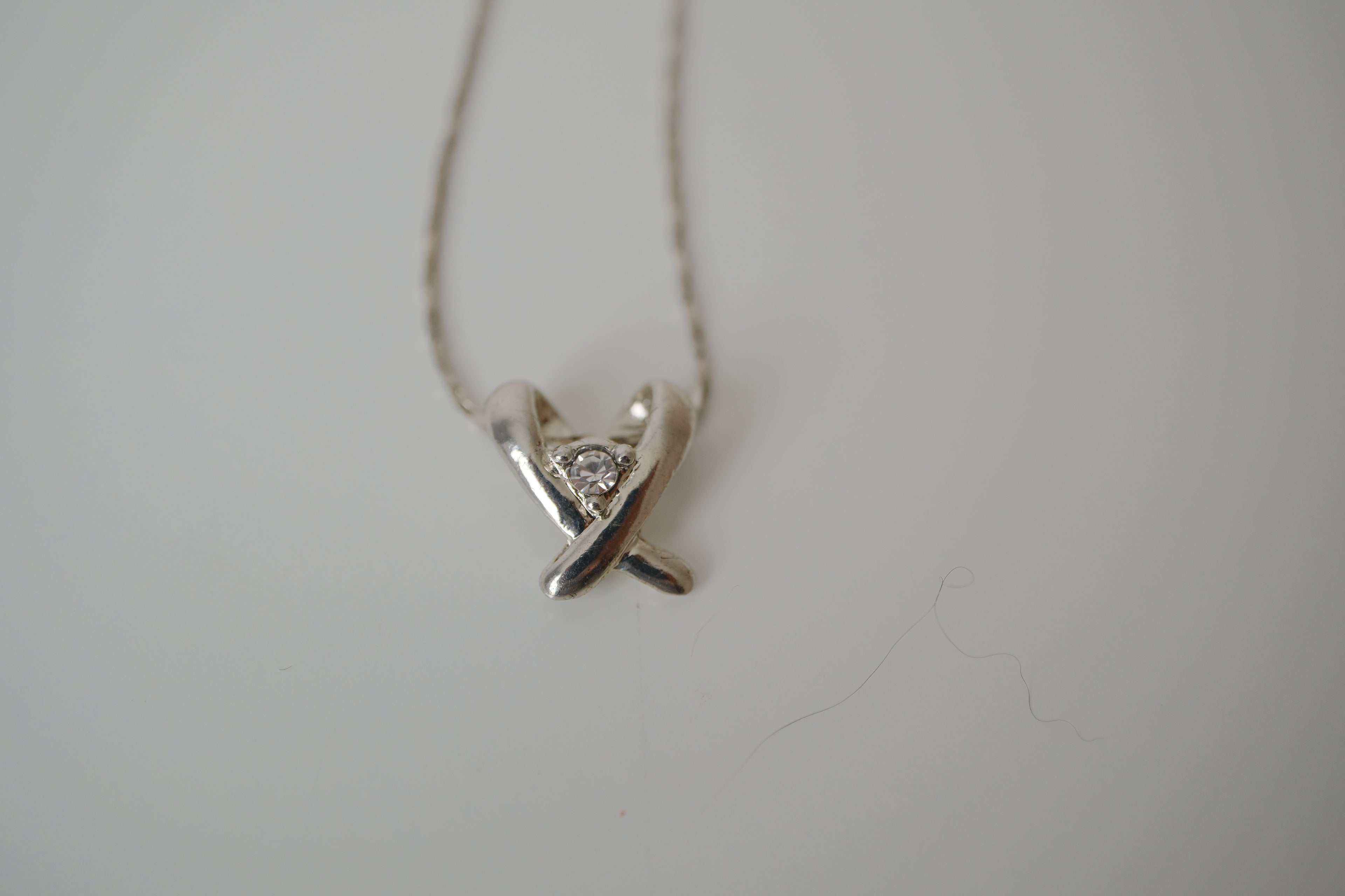 Silver toned Kiss pendant necklace