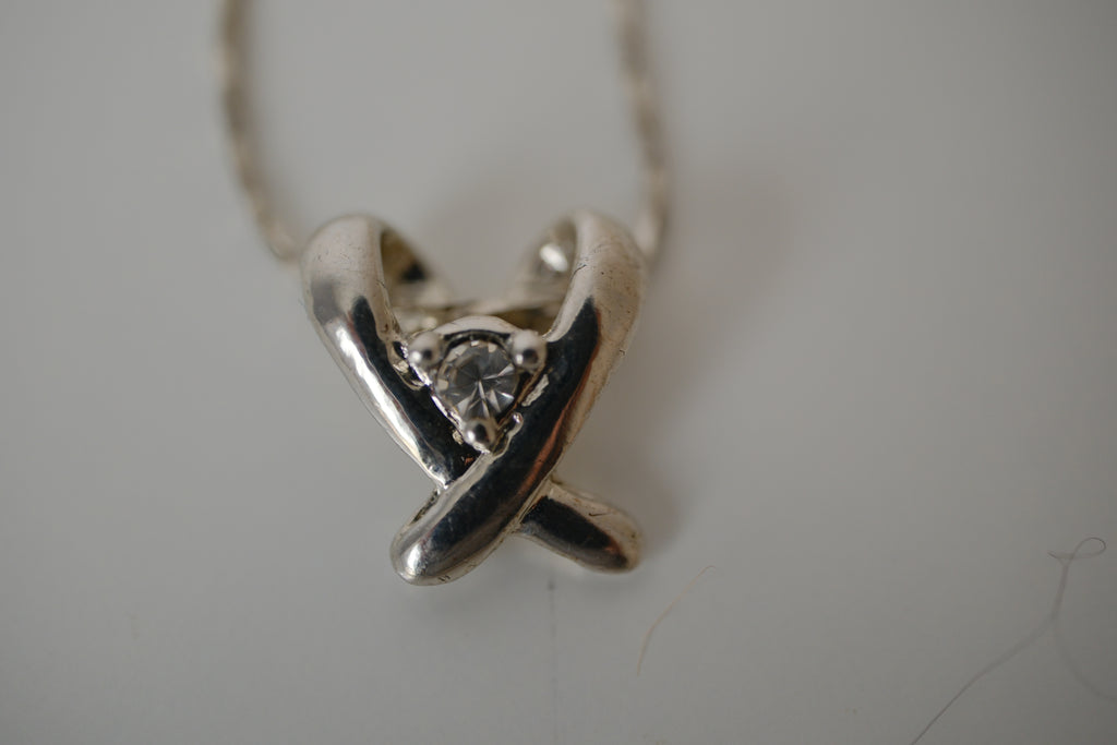 Silver toned Kiss pendant necklace